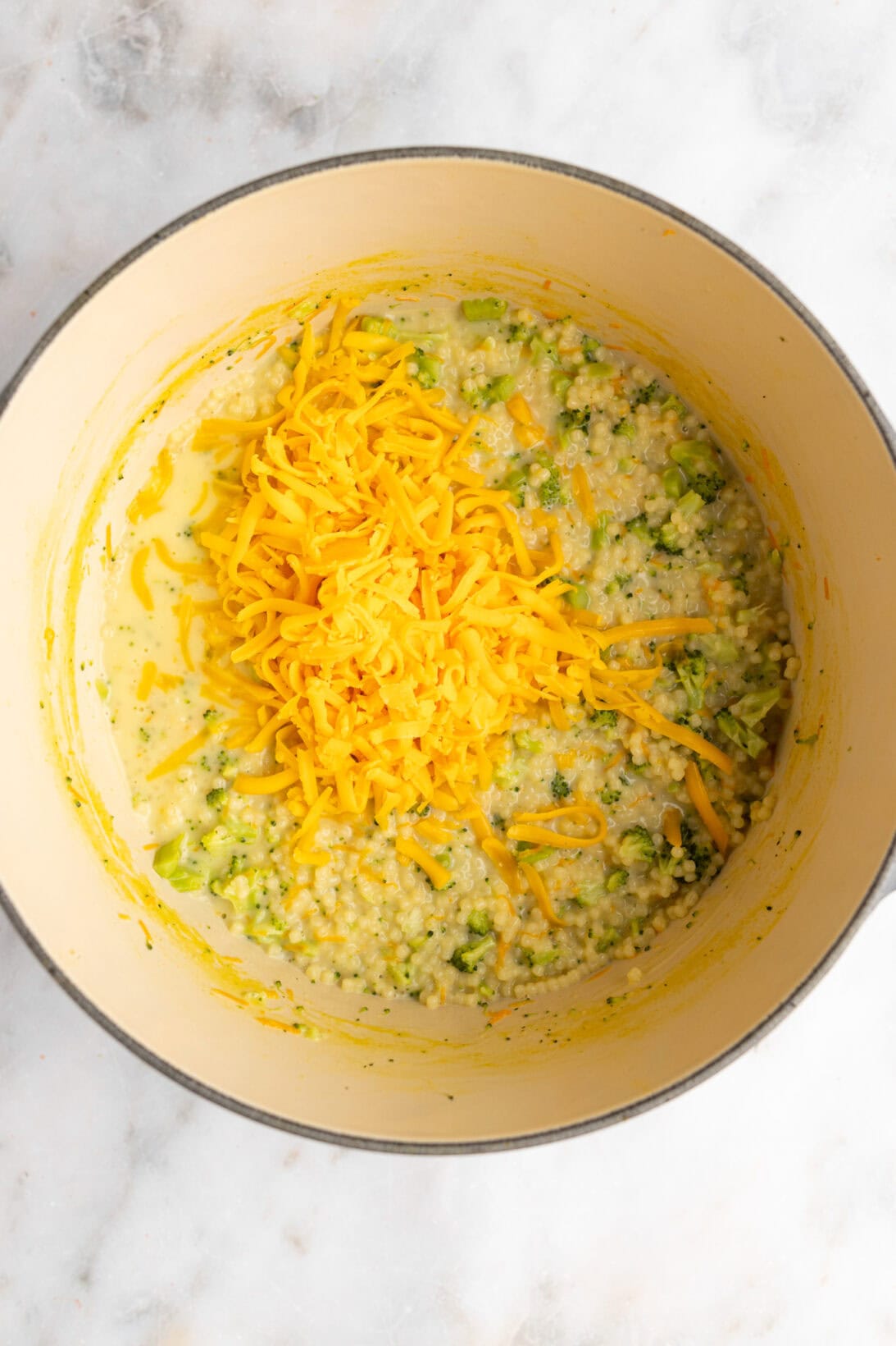 step by step: pastina is cooked, adding in the heavy cream and cheese.