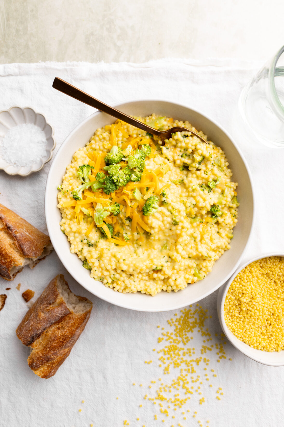 a bowl of broccoli cheddar pasta, with crusty bread. 