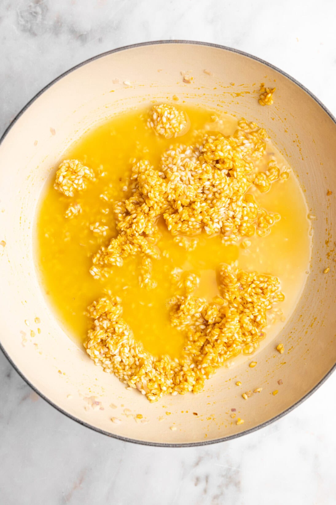 step by step: adding the first addition of broth to the creamy pumpkin risotto.