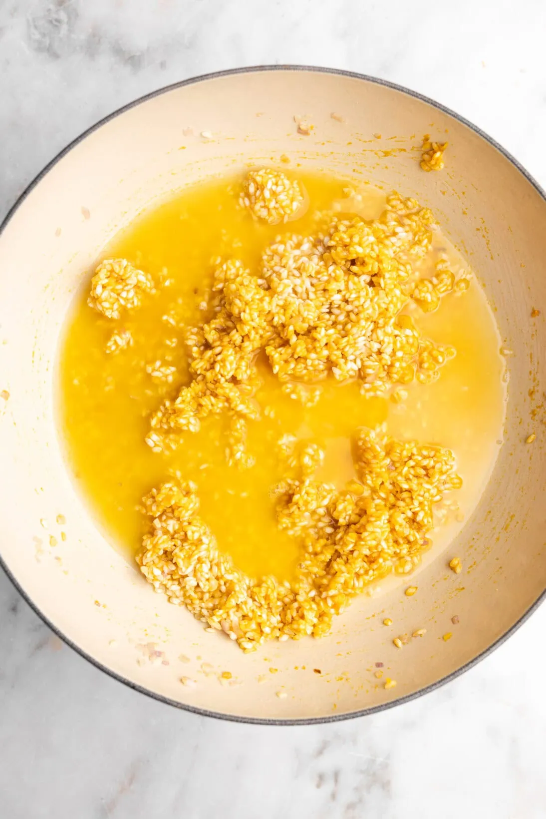 step by step: adding the first addition of broth to the creamy pumpkin risotto.