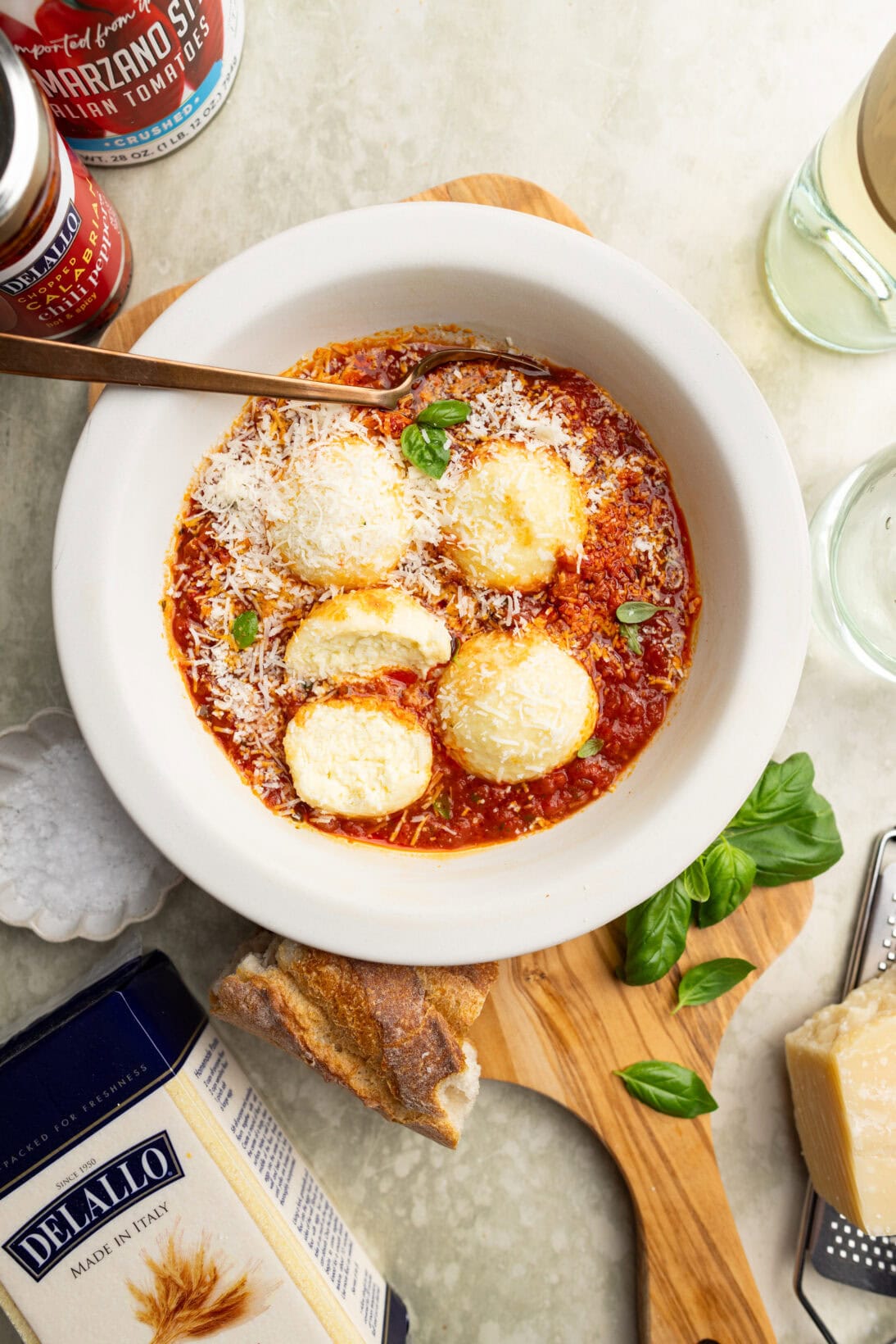 a bowl of ricotta gnudi in a spicy red sauce topped with Parmesan cheese