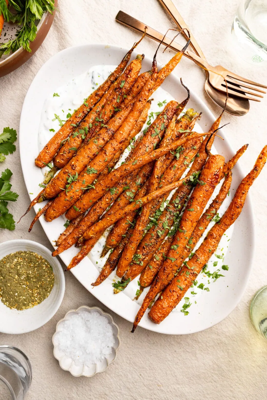 a long plate of za'atar roasted carrots over a garlicky yogurt sauce