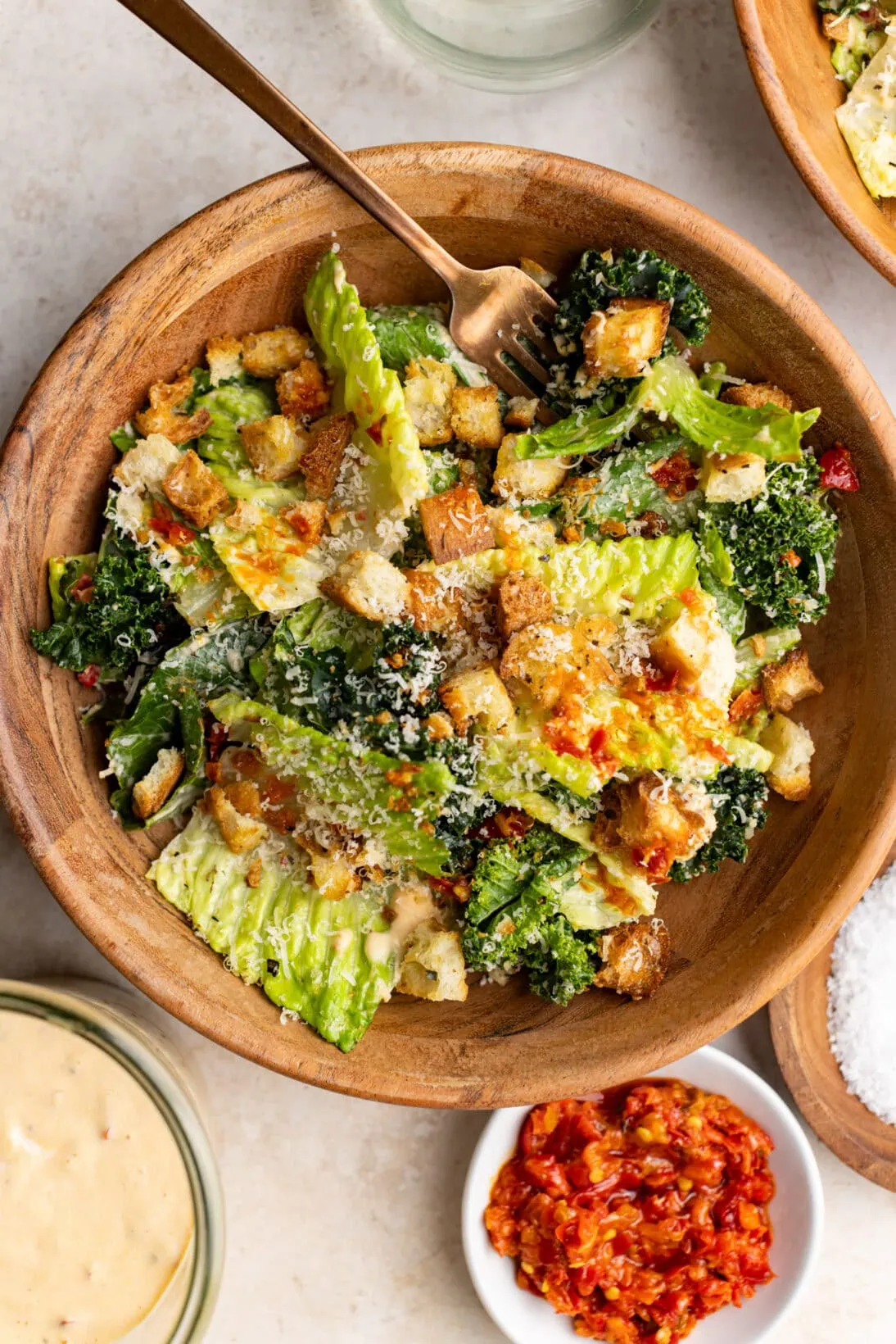 served spicy Caesar salad in a wooden bowl.