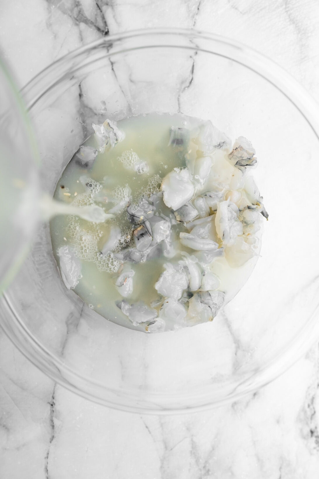 pouring lime juice over shrimp.