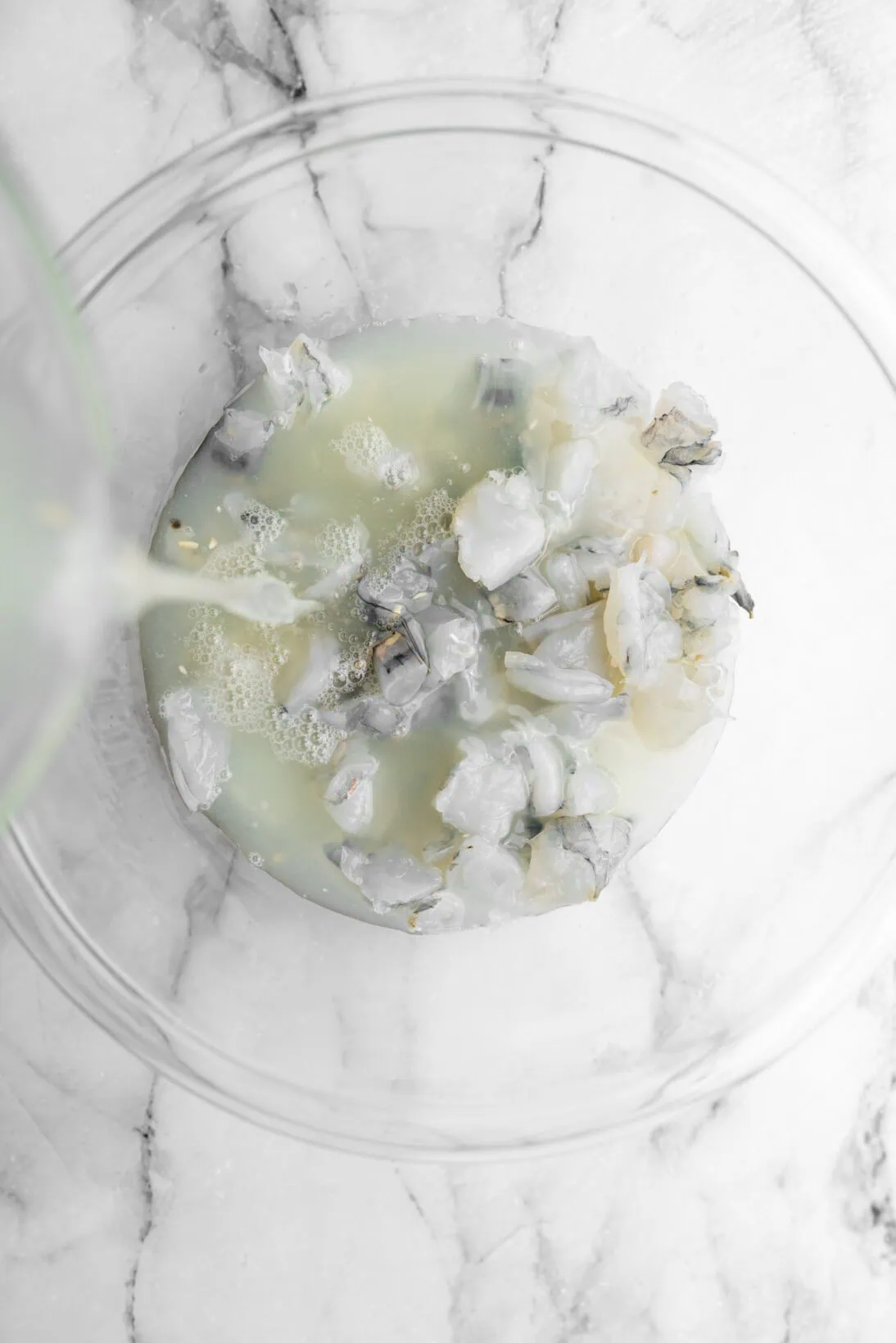 pouring lime juice over shrimp.