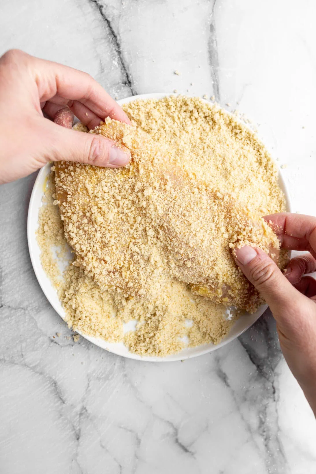 coating the chicken in breadcrumbs