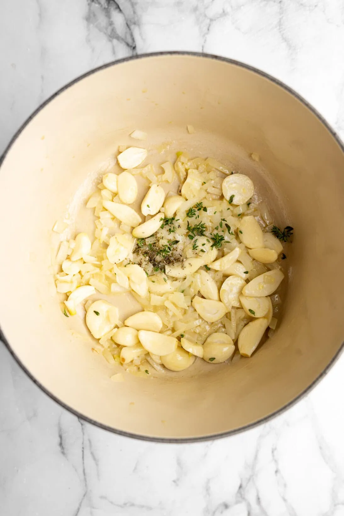 step by step: sautéing the garlic cloves, onion, and thyme.