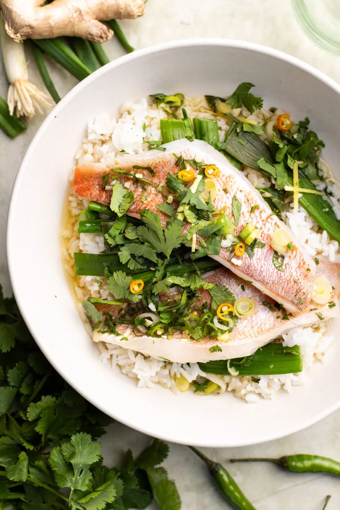 a bowl of Asian steamed fish over fluffy rice.