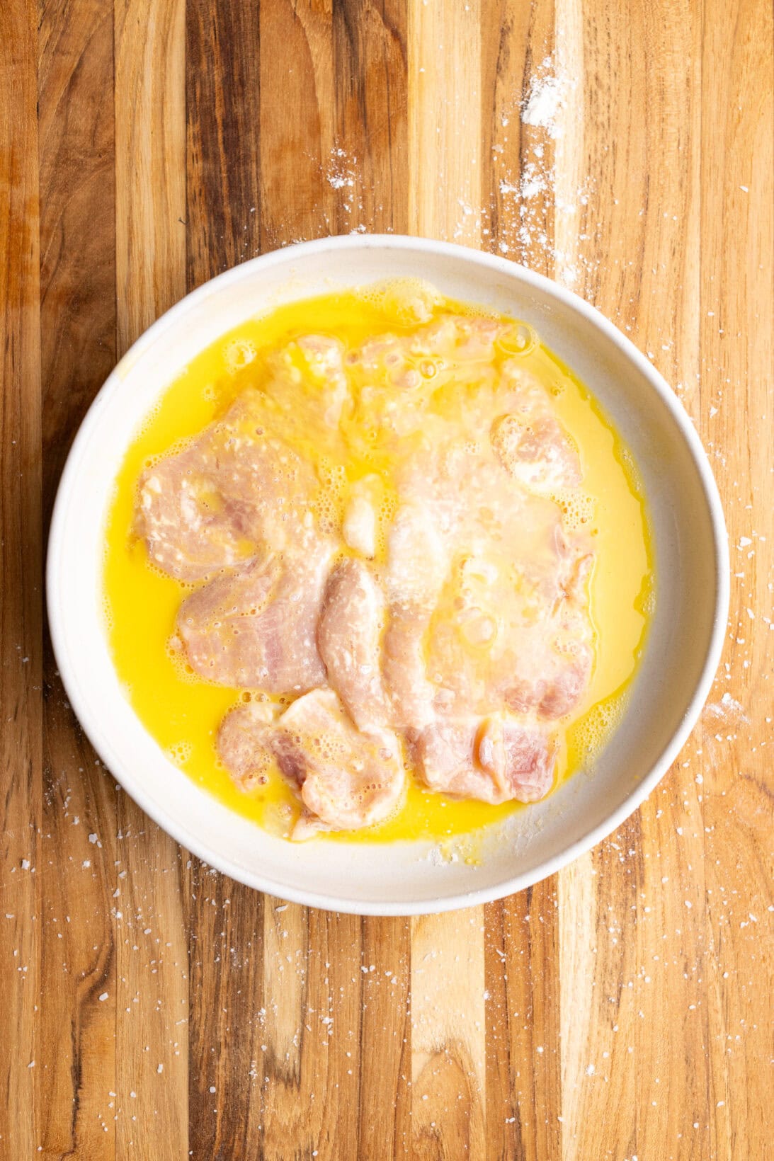 coating the flour coated chop in egg