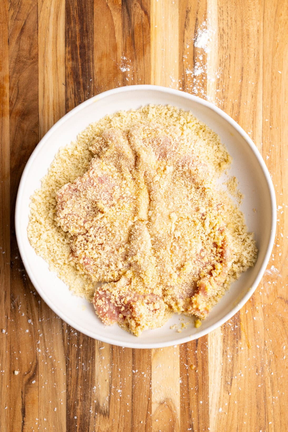 coating the egg coated chop in the breadcrumb mixture
