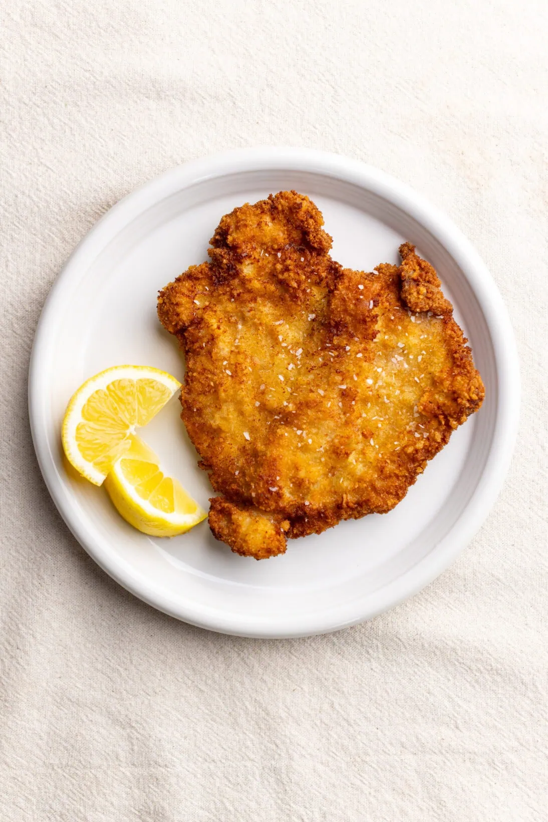 Pork schnitzel on a plate with lemon wedges