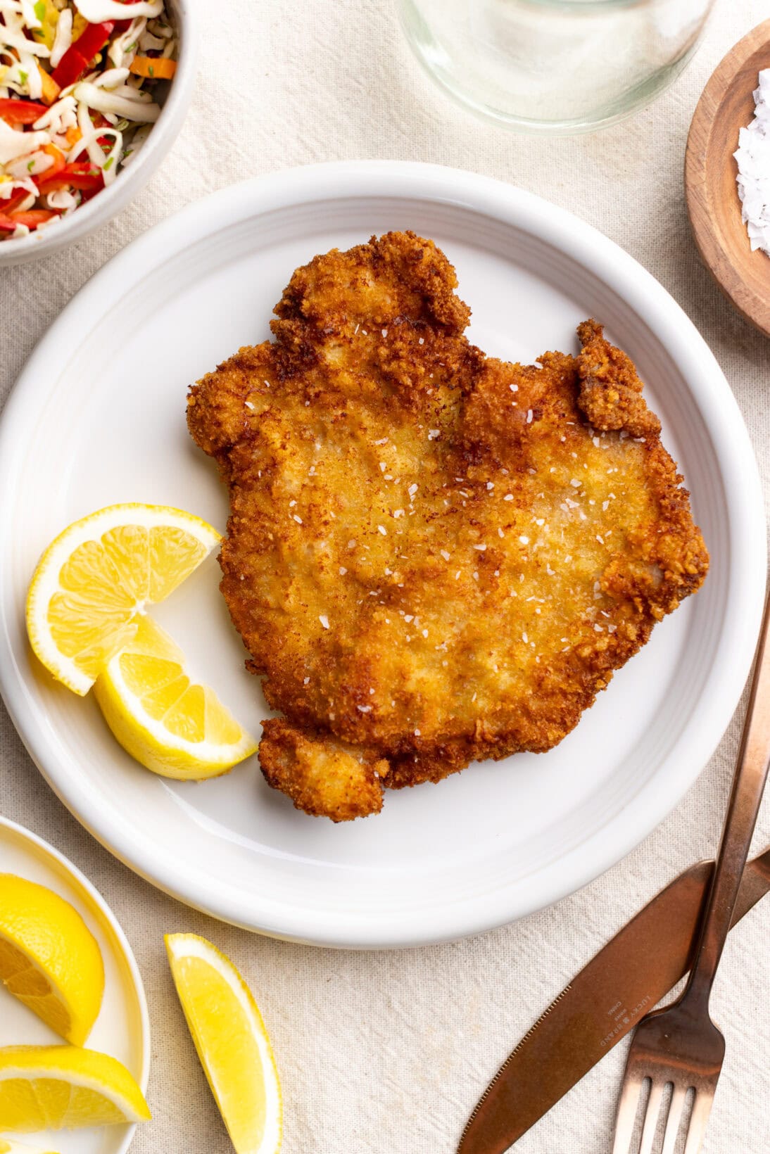 Pork schnitzel on a plate with lemon wedges