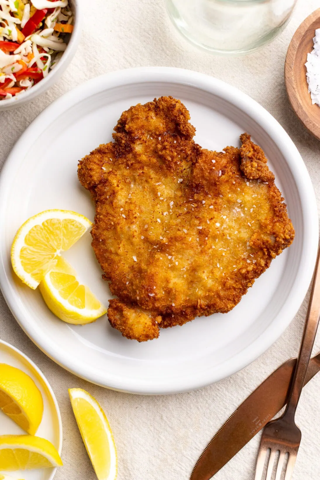 Pork schnitzel on a plate with lemon wedges