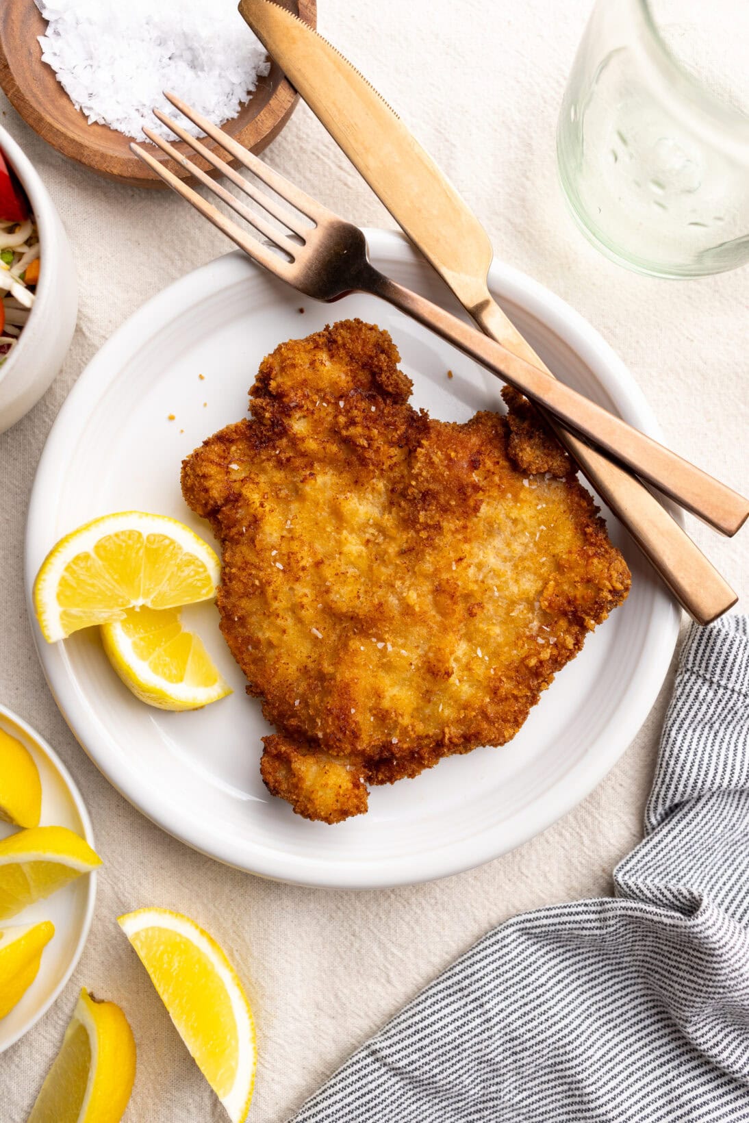Pork schnitzel on a plate with lemon wedges