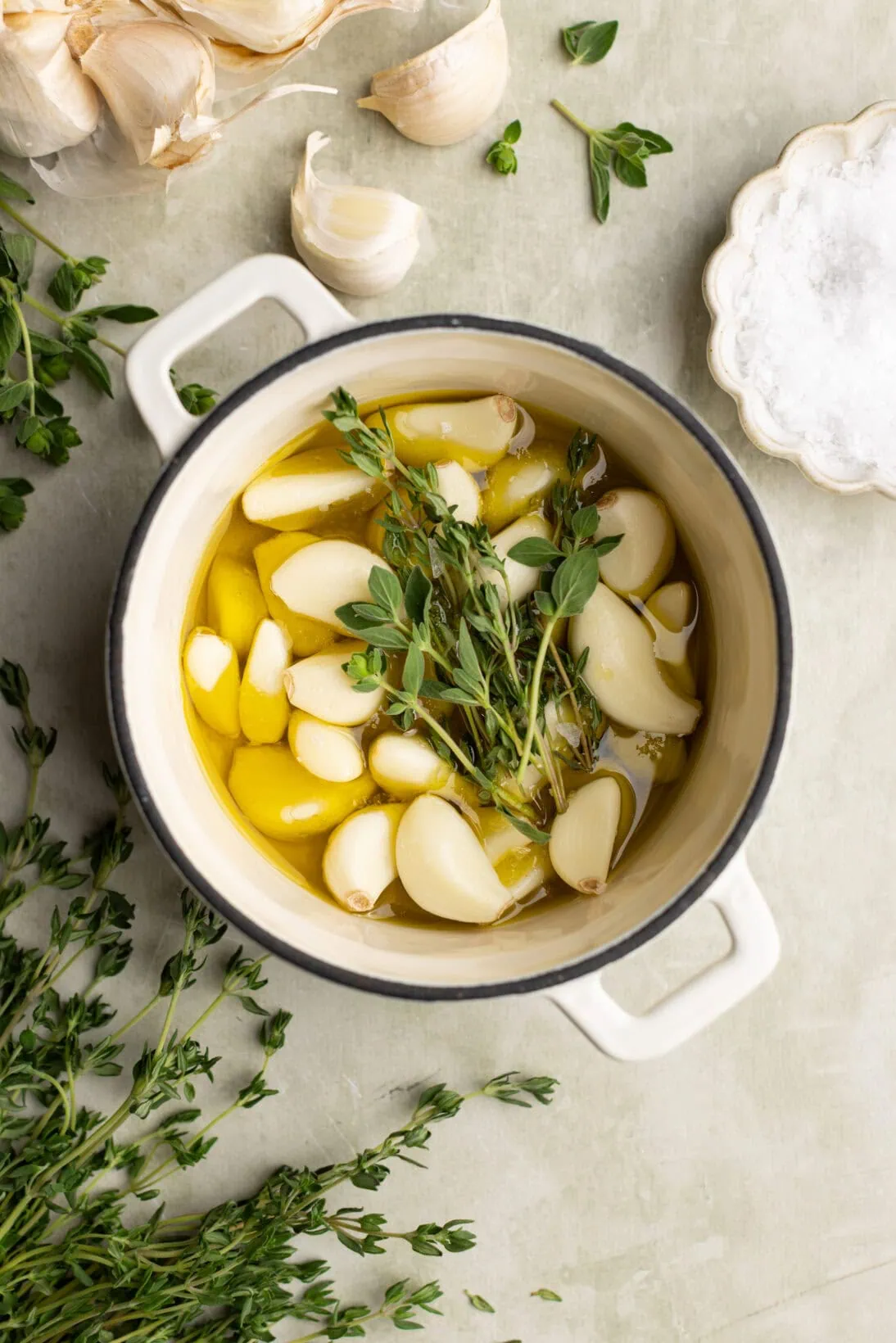 garlic in a cocotte with olive oil, thyme, and fresh oregano.