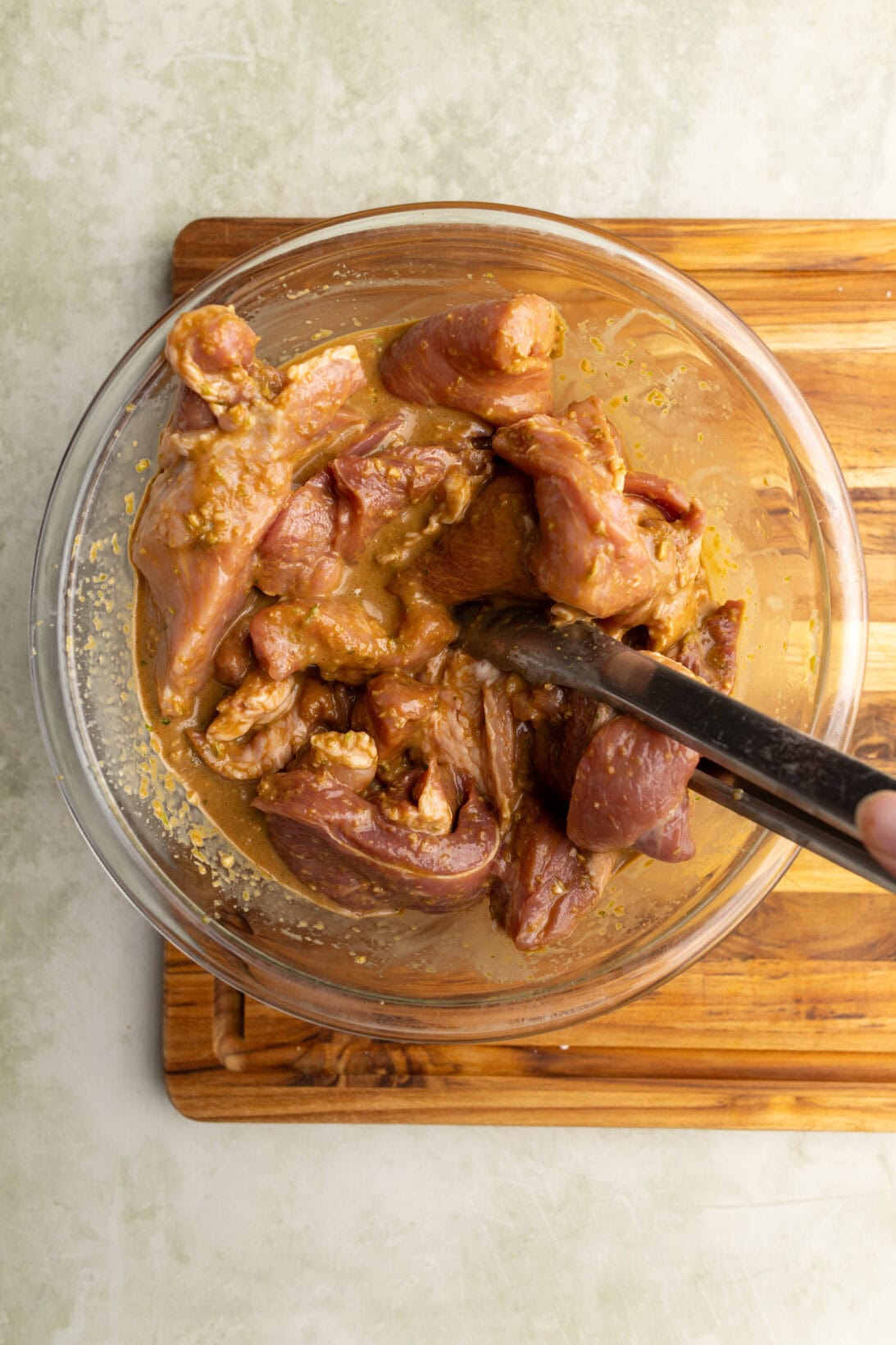 step by step:  throughly mixing the marinade with the pork.