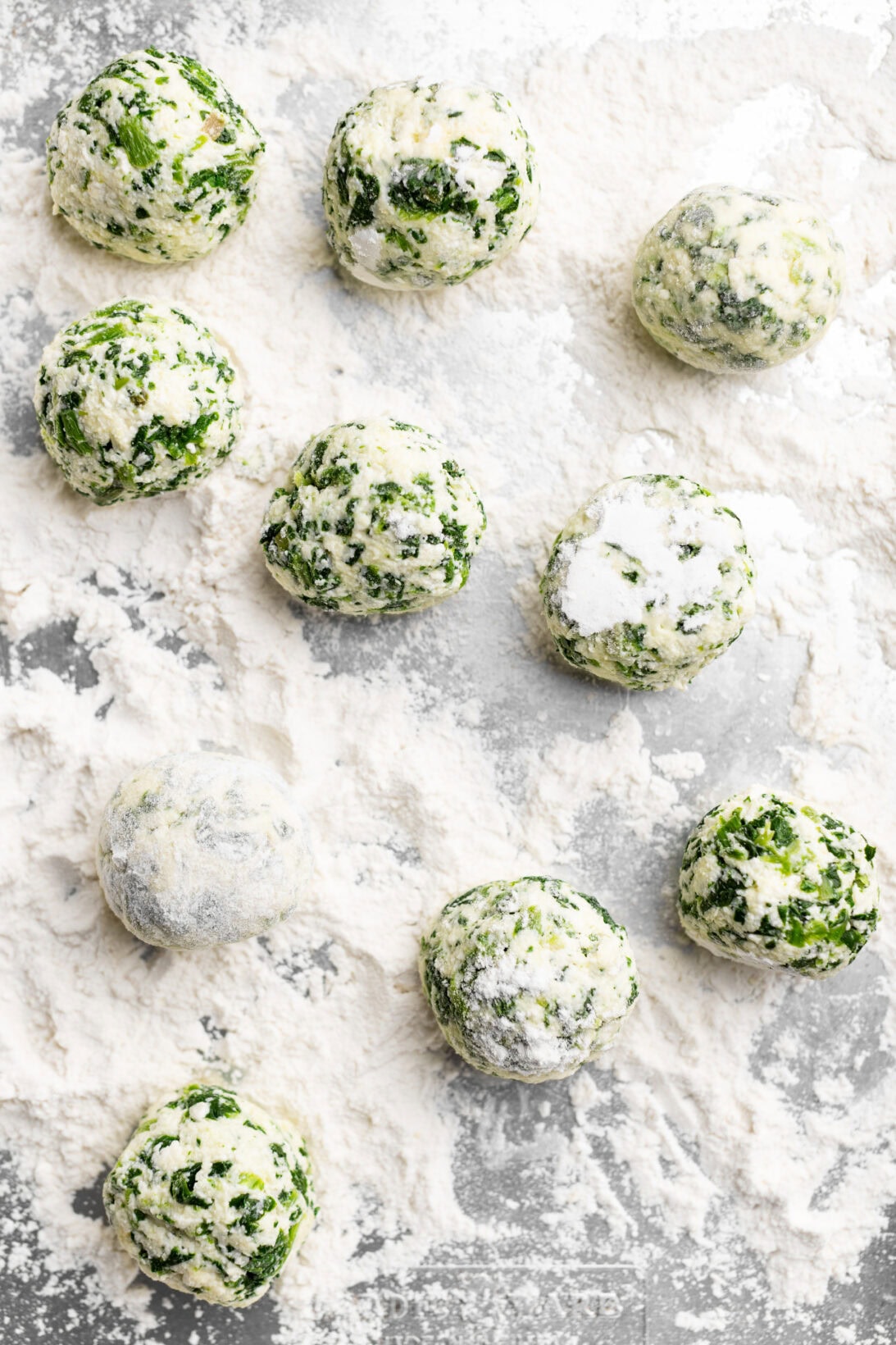 rolling the spinach and ricotta gnudi in all-purpose flour.