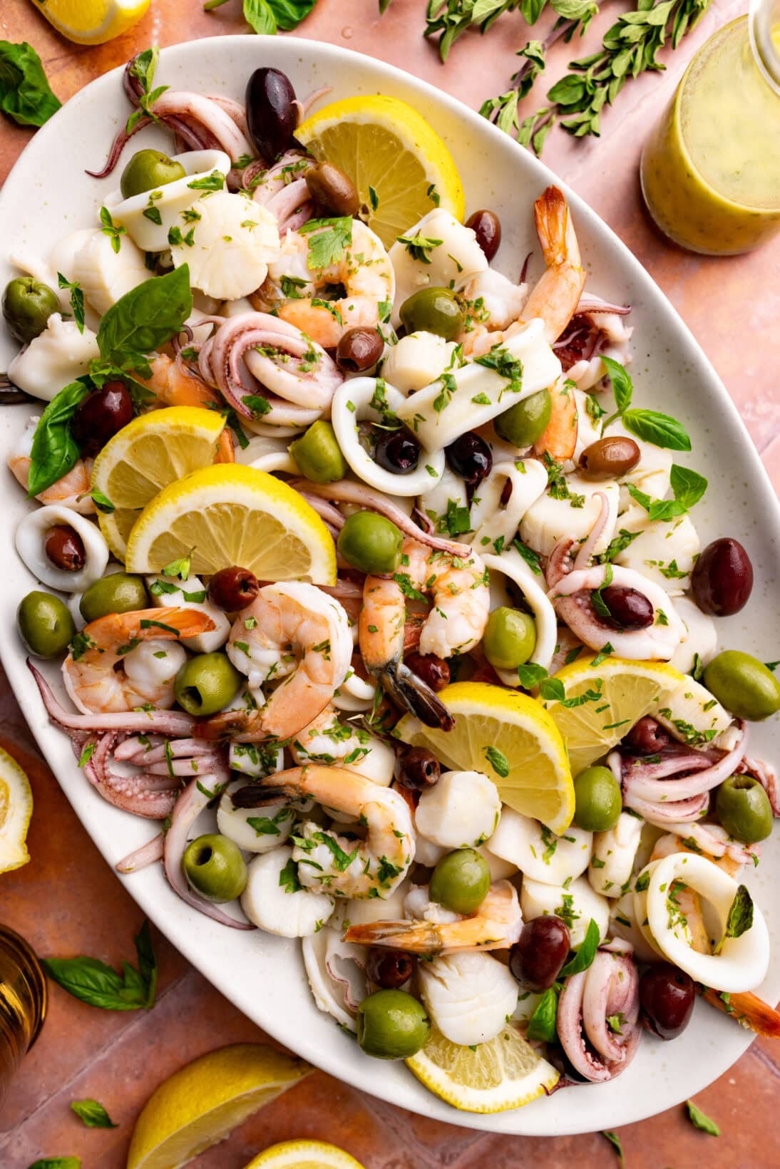 a serving plate of insalata di mare. served with slices of lemon.