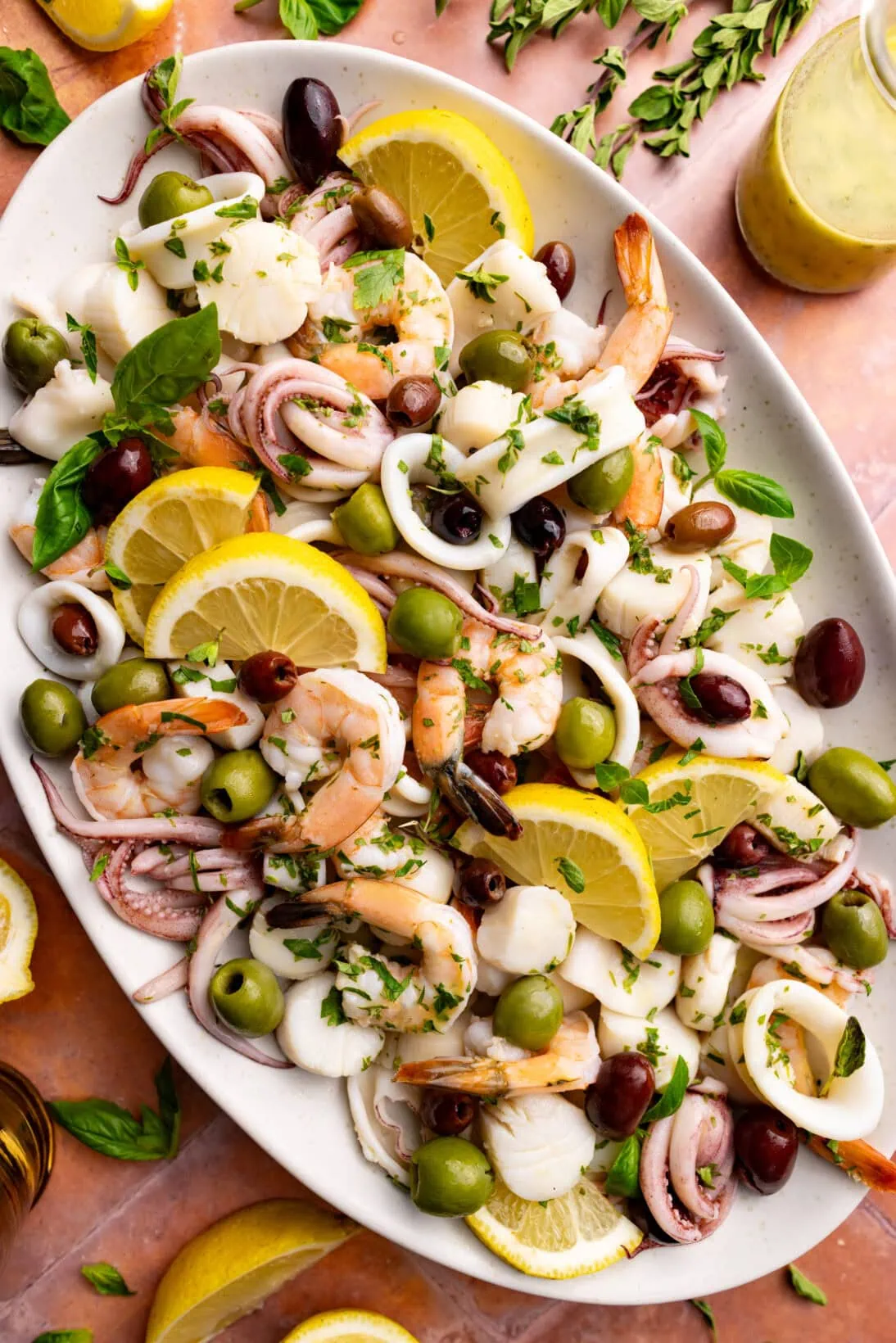a serving plate of insalata di mare. served with slices of lemon.