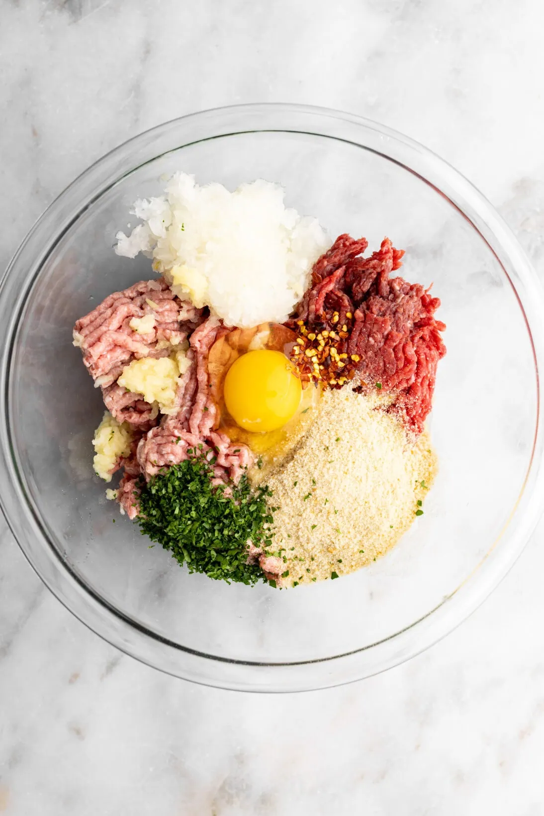 step by step: ingredients in a bowl (ground beef, ground turkey, egg, breadcrumbs, garlic, onion, chili flakes, parsley)