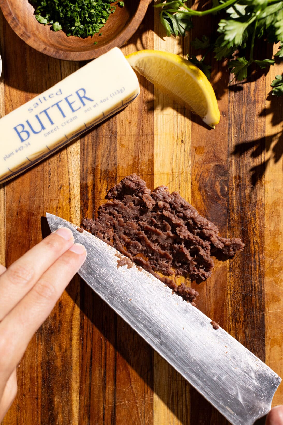 step by step: sliding the knife against the anchovies to create a paste