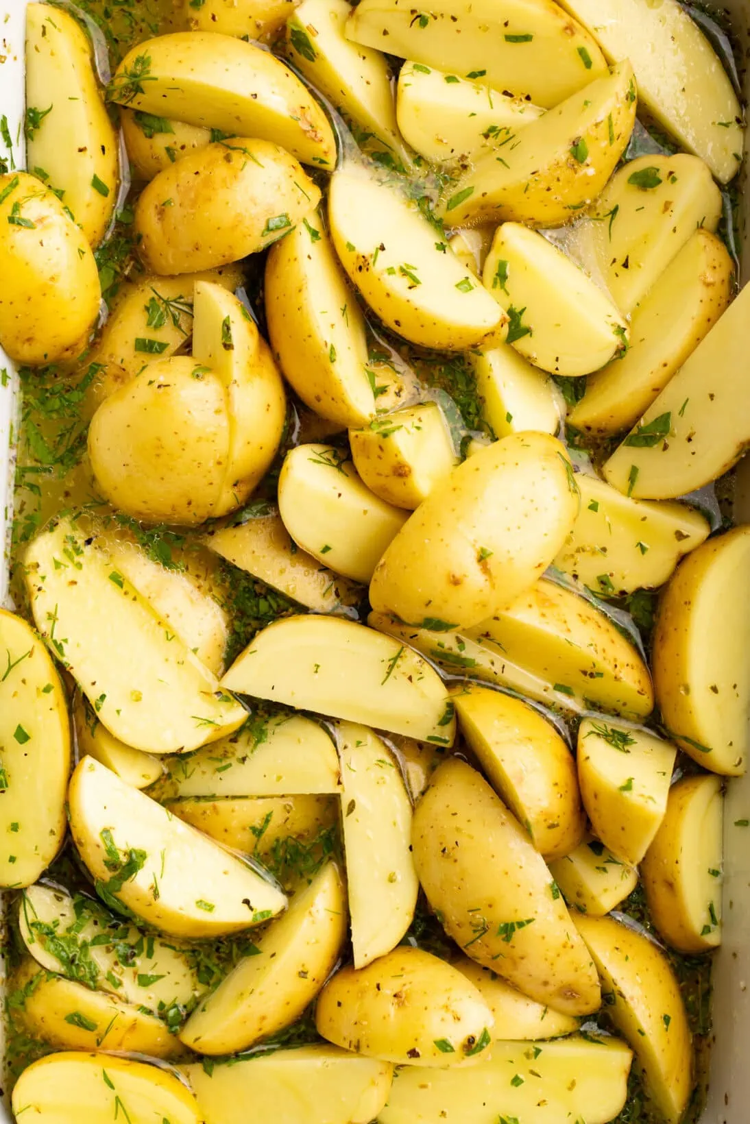 step by step: seasoning the potatoes and adding the broth and lemon juice. before roasting.