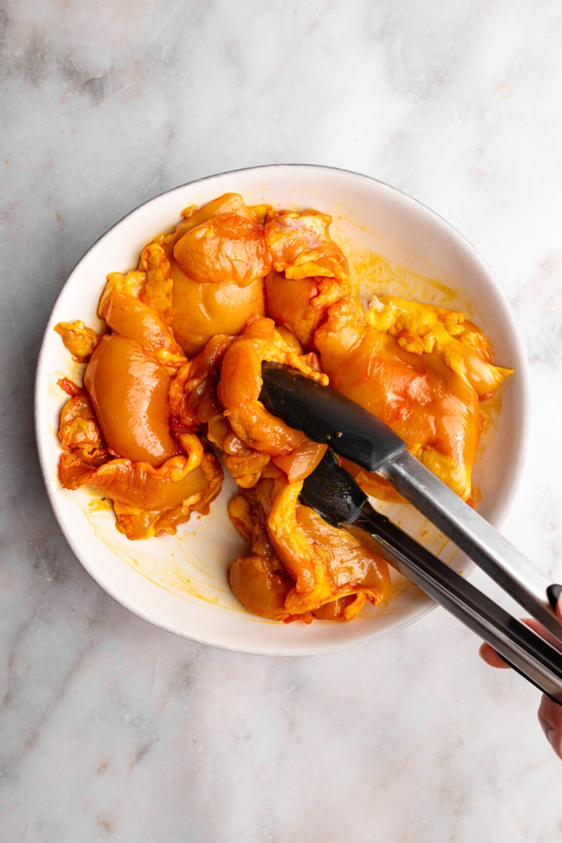 marinating the chicken in sazon.