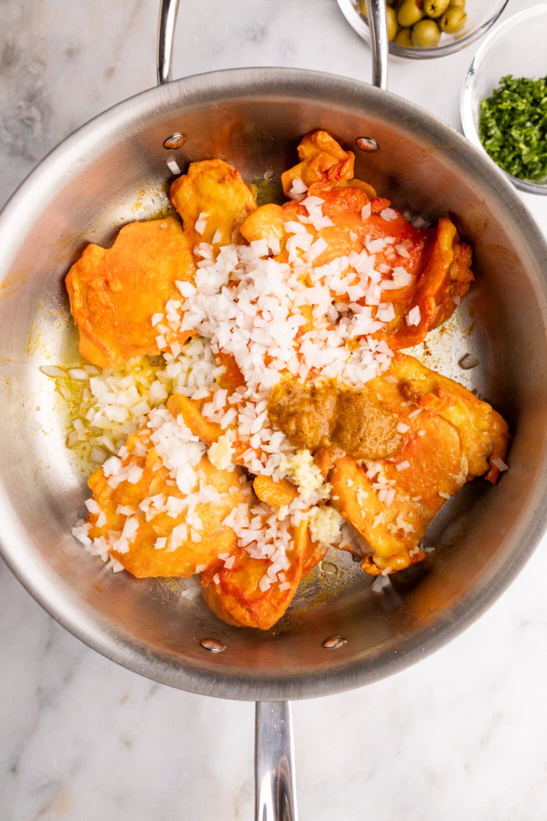 step by step: adding the onions, garlic, and sofrito to the pan