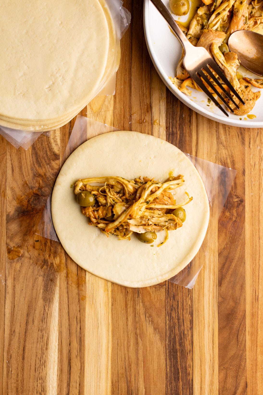 step by step: stuffing the chicken empanadas with 2-3 tbsp of filling.