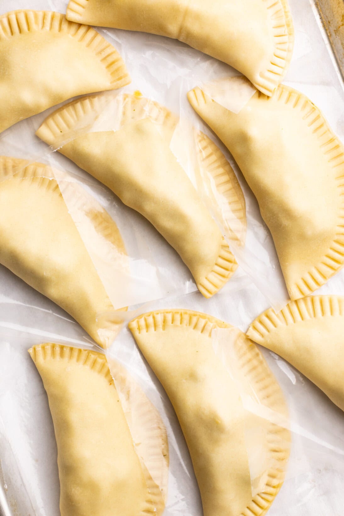 step by step: prepped chicken empanadas on a sheet tray