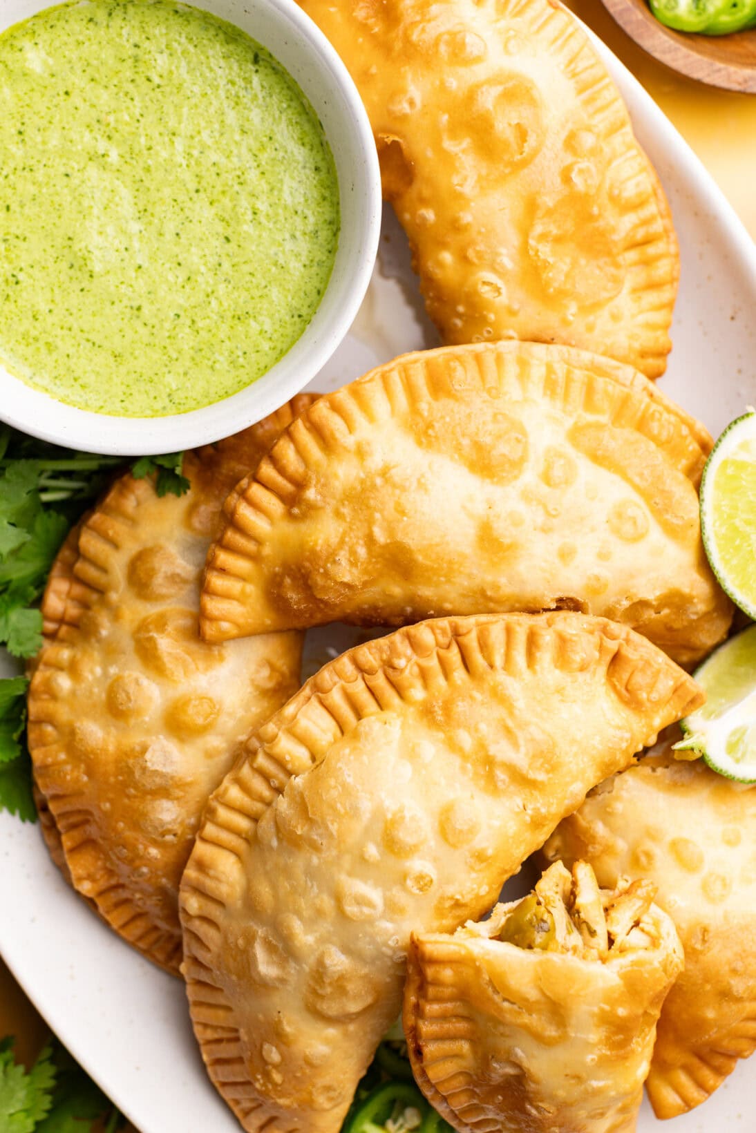 step by step: a plate of chicken empanadas with garlic sauce.