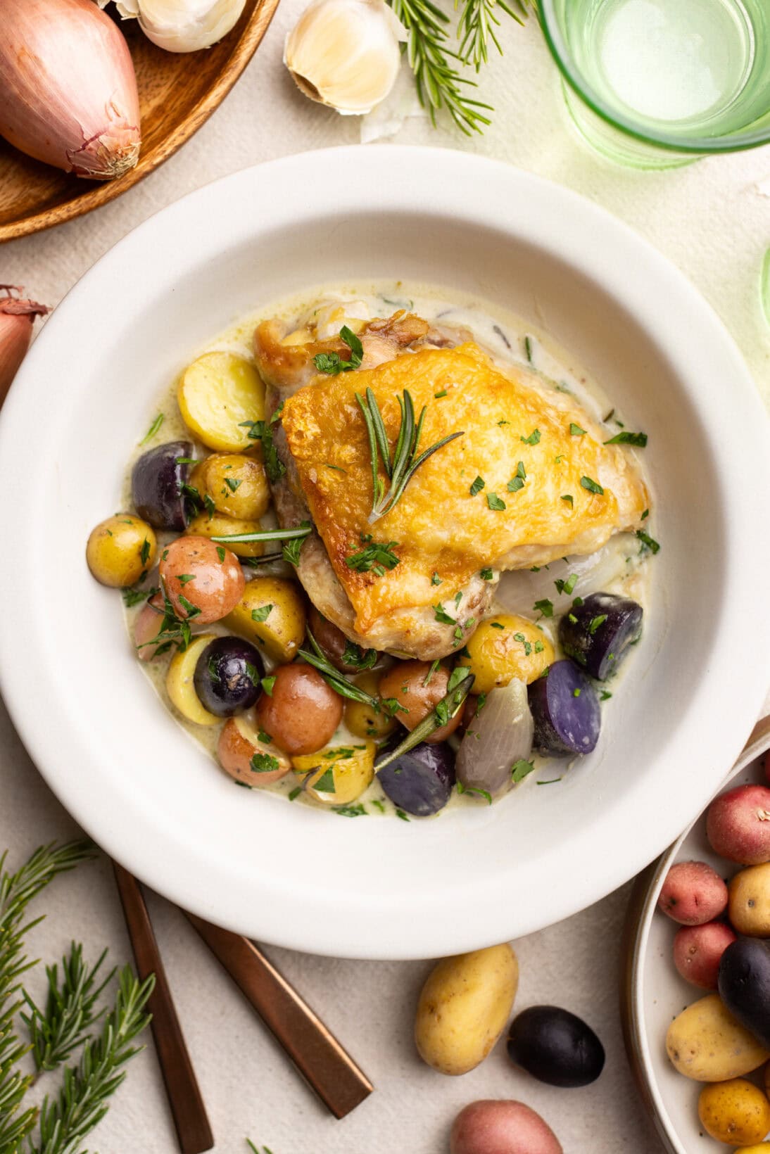 a bowl with rosemary chicken over tender potatoes and the rosemary cream sauce