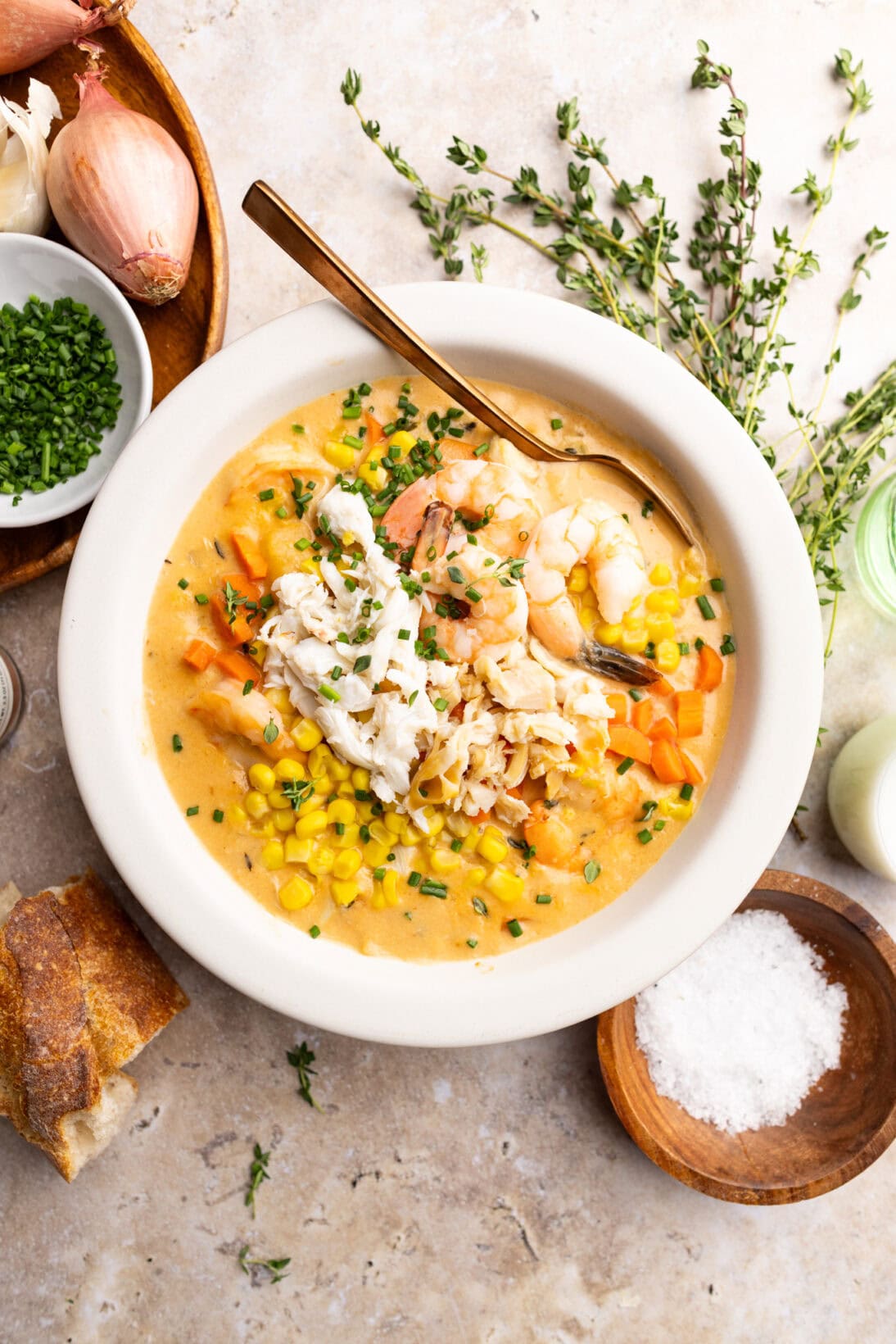 a bowl of seafood chowder topped with crab, shrimp, and clam meat.