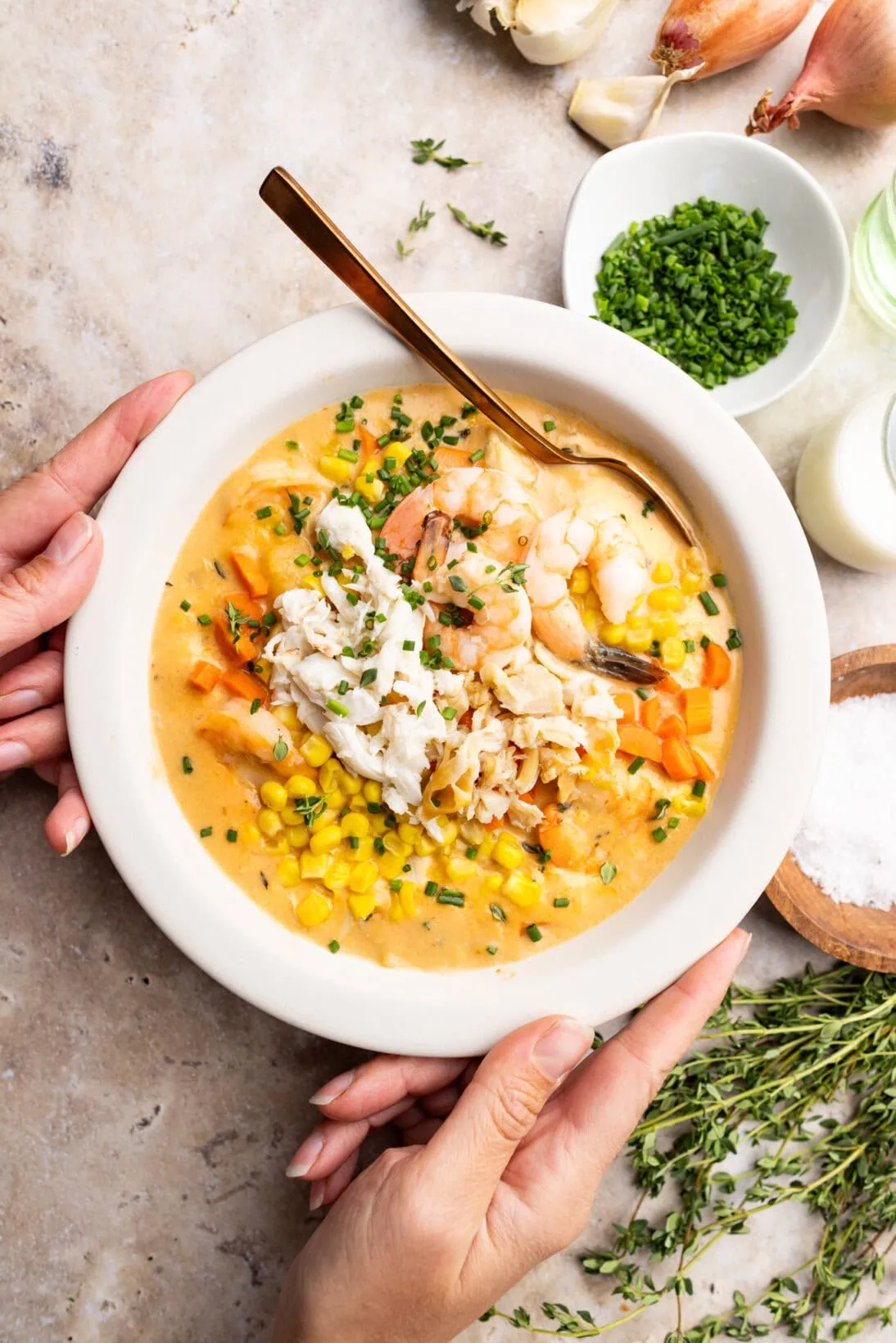 a bowl of seafood chowder topped with crab, shrimp, and clam meat.
