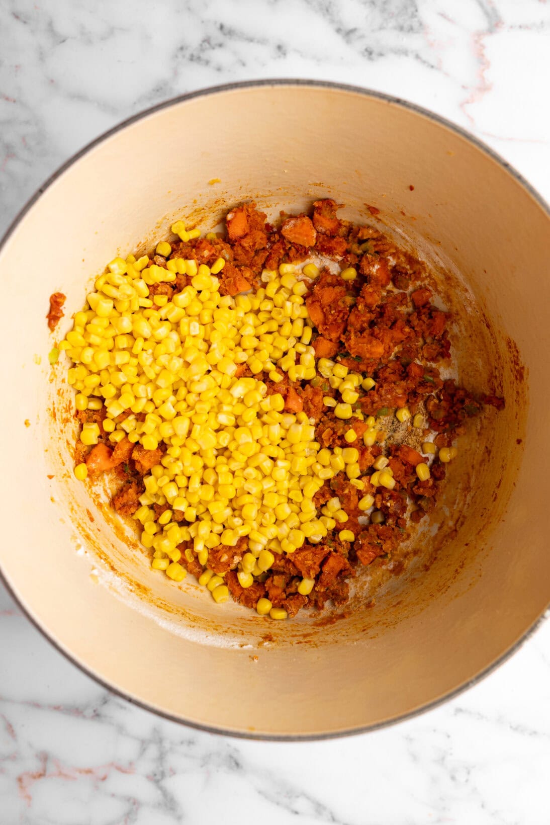 step by step: added the tomato paste, and flour to make a roux, then tossed in the corn.