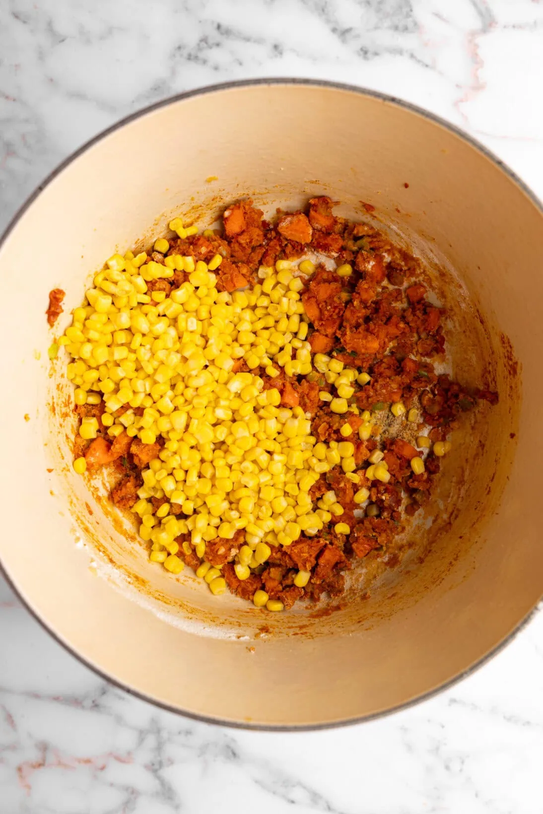 step by step: added the tomato paste, and flour to make a roux, then tossed in the corn.
