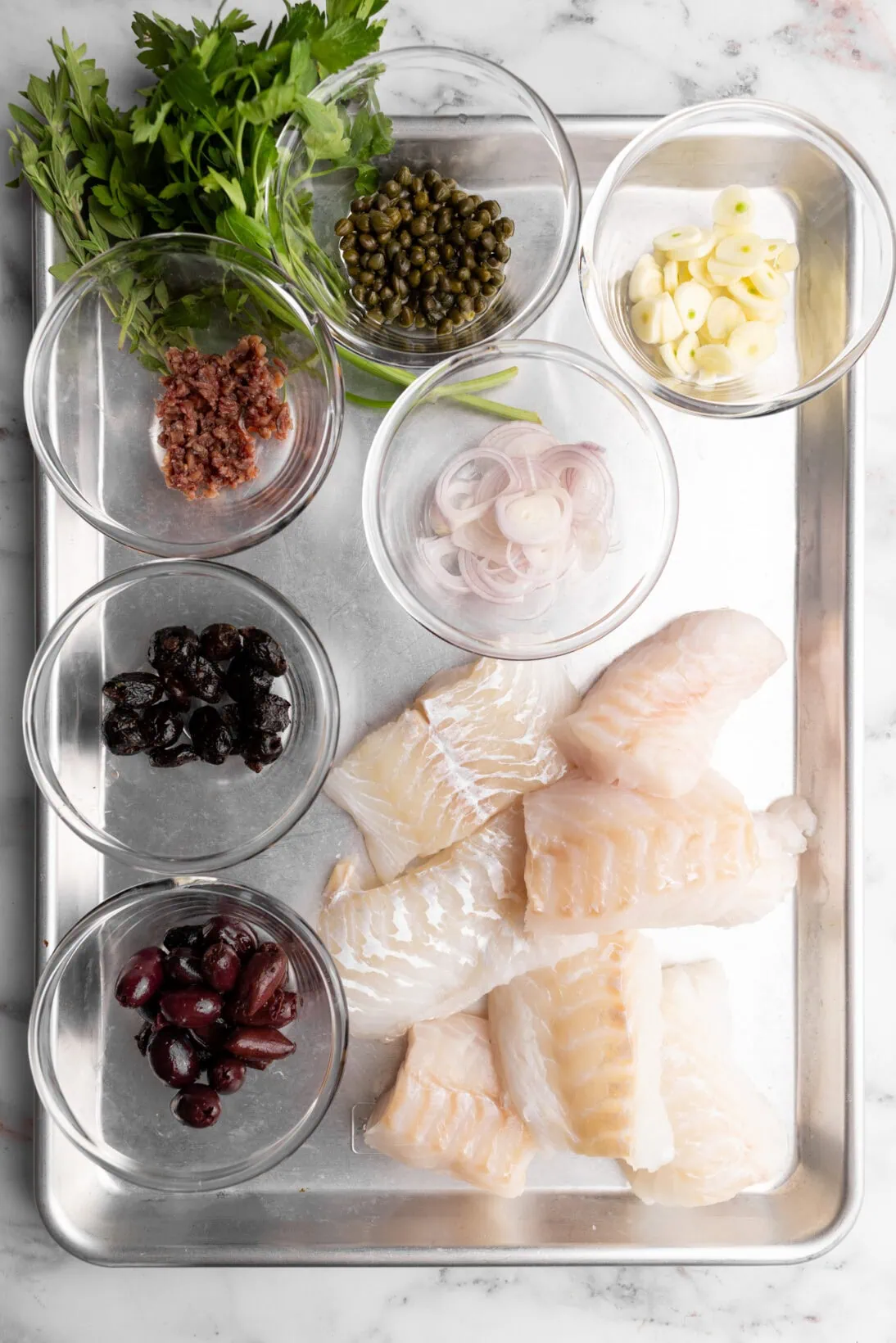 Ingredients: cod, cured black olives, kalamata olives, shallots, garlic, anchovies, capers, and parsley. Not in image, crushed tomatoes.