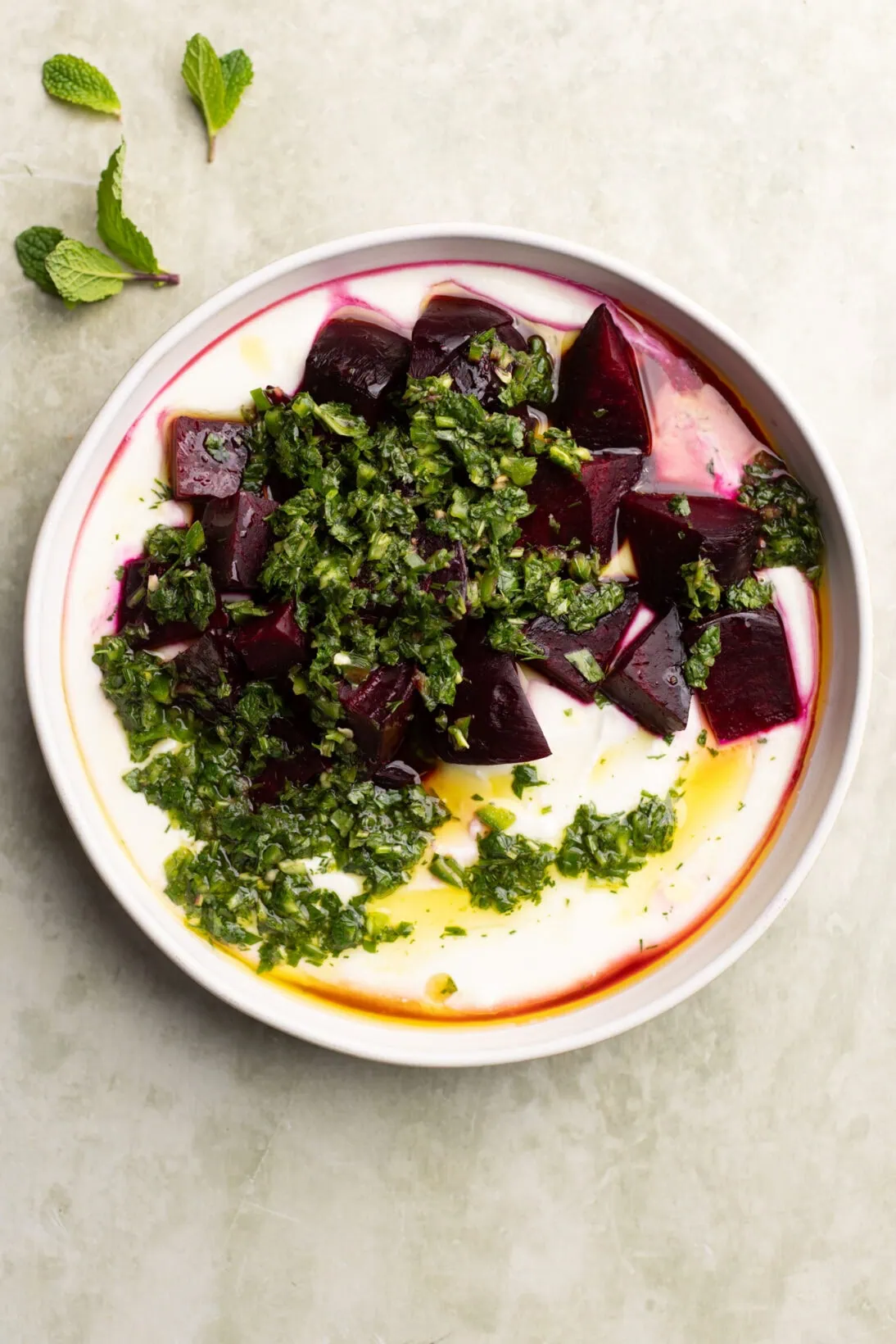 a plate of roasted beets and whipped feta dip topped with the cilantro and mint gremolata.