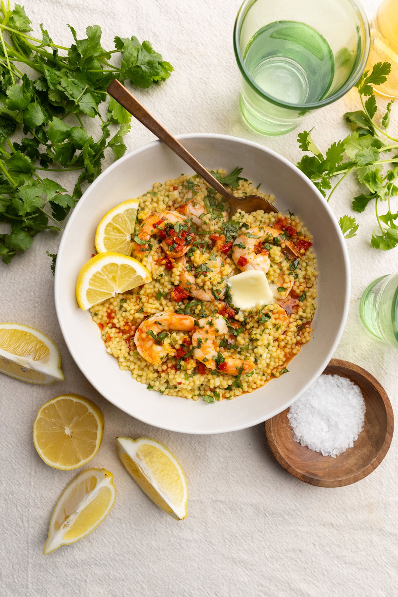 Bowl of pastina with spicy garlic shrimp topped with lemon.