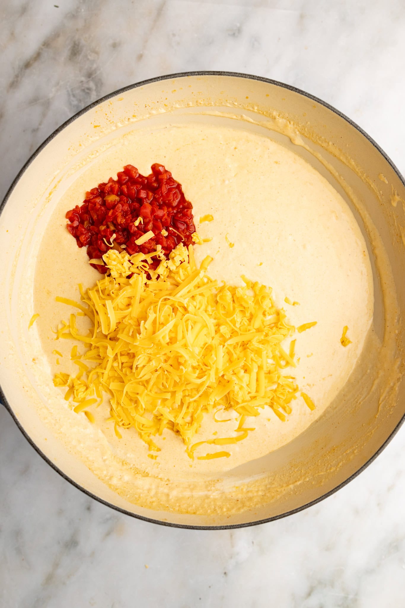 step by step: adding the pimento and cheddar to the sauce.