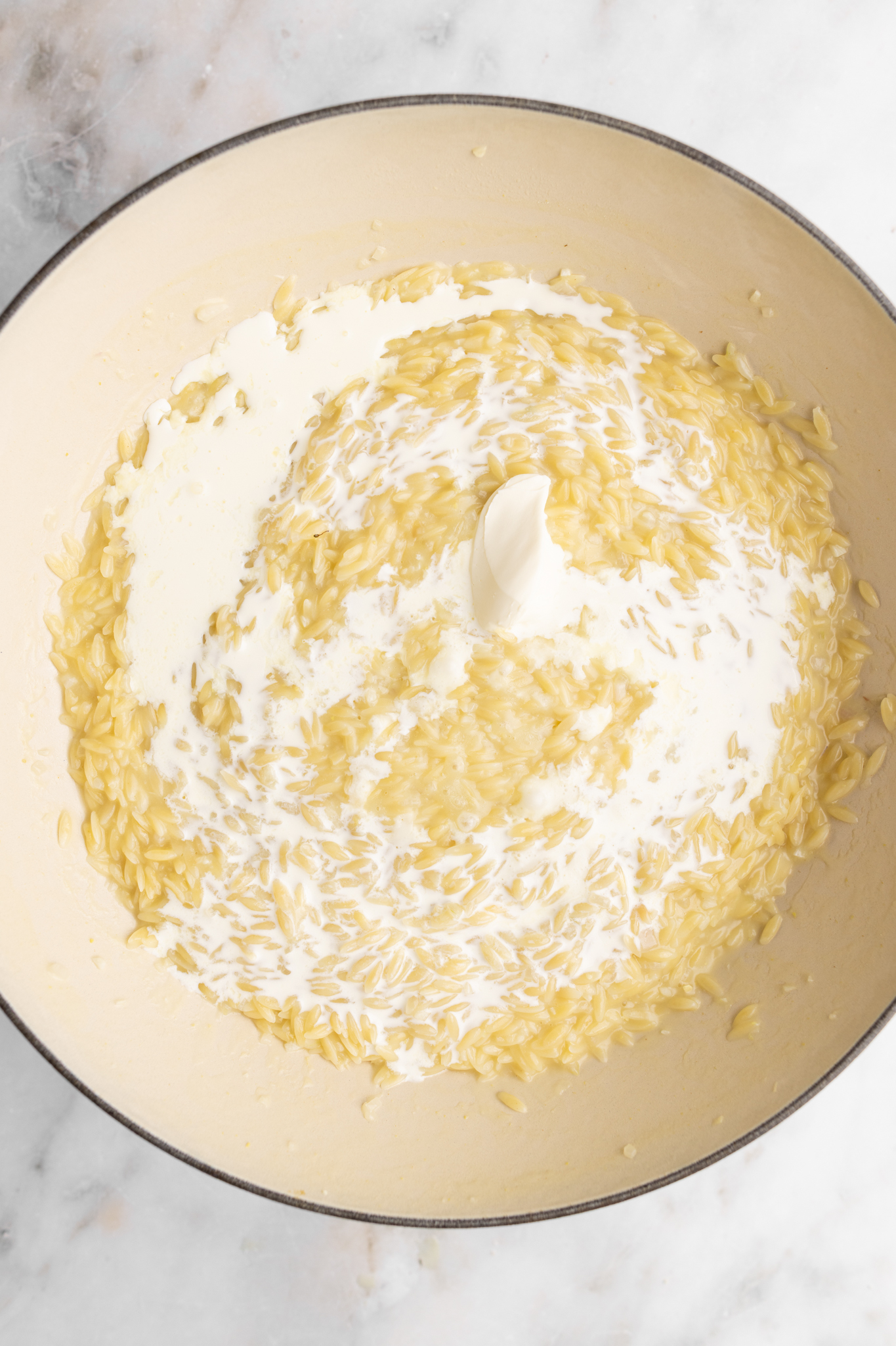 step by step: finishing the orzo risotto with heavy cream, and mascarpone cheese