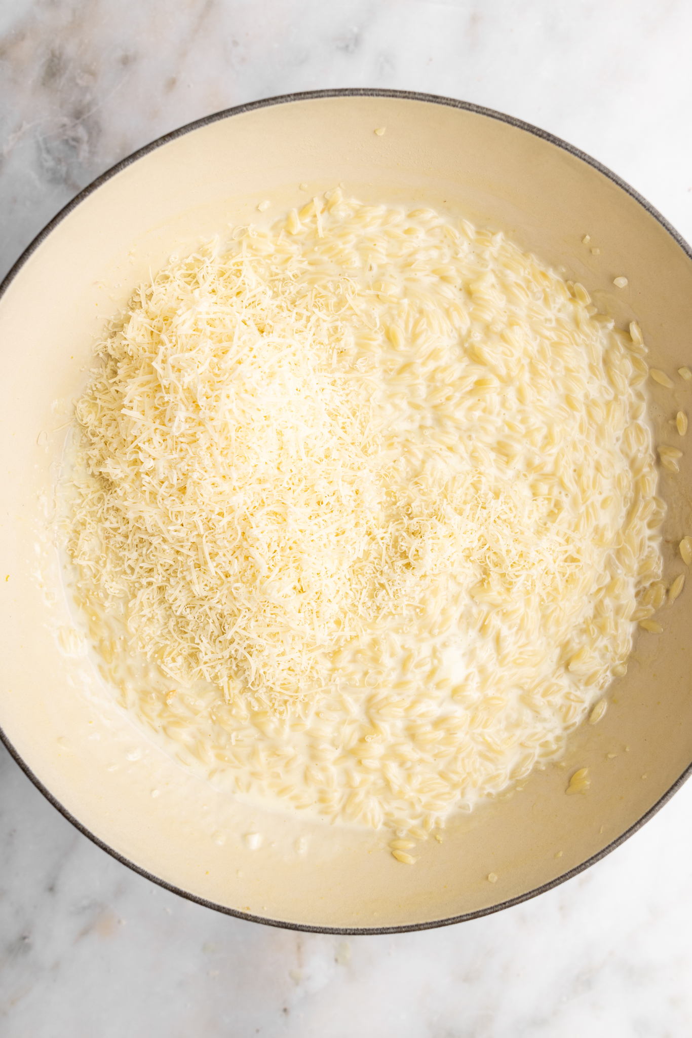 step by step: adding the final Parmesan to the cooked orzo risotto