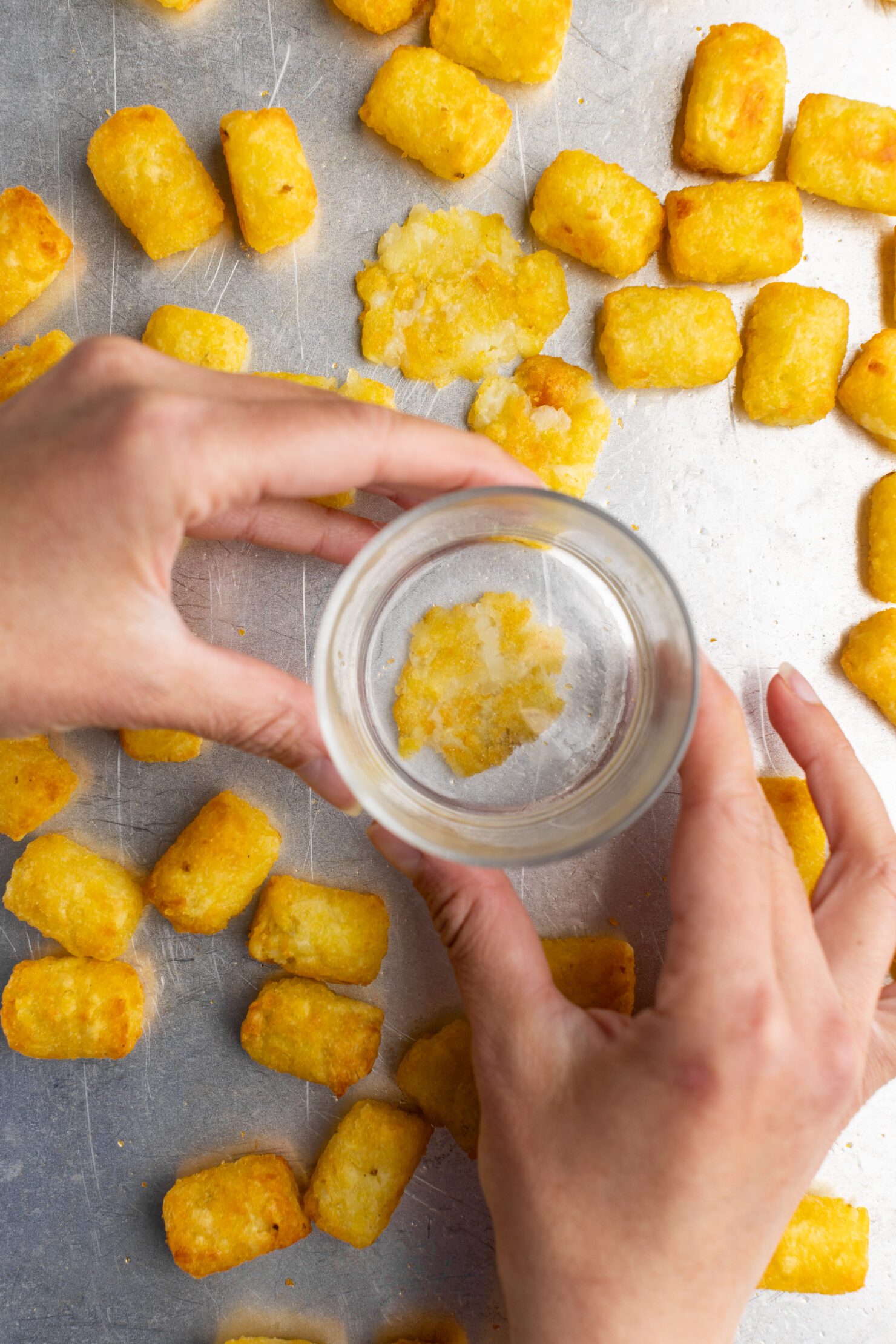 step by step: smashing the tater tots with the bottom of a glass.