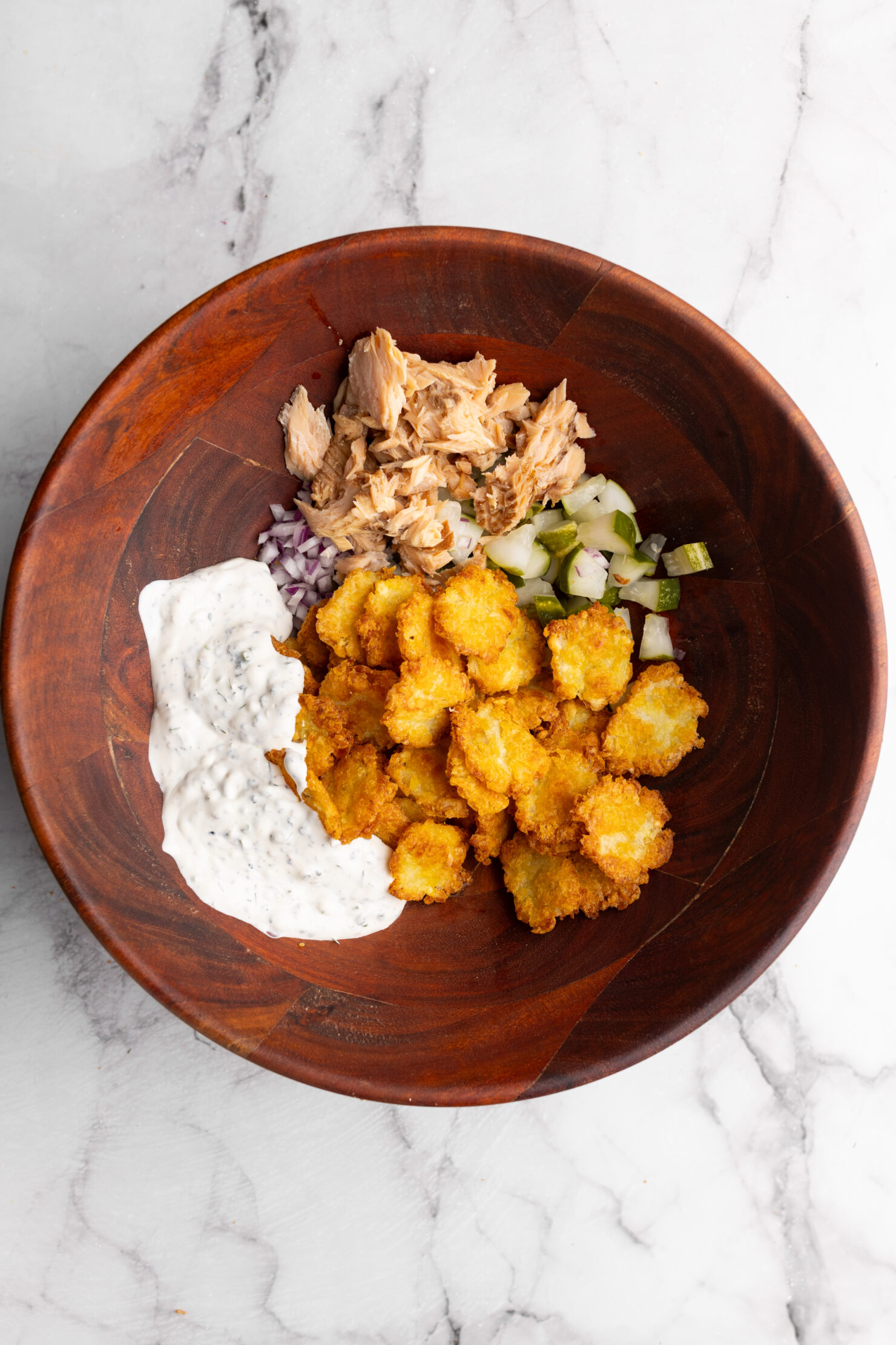 step by step: all the ingridents in a large bowl ready for mixing the crispy potato  salad