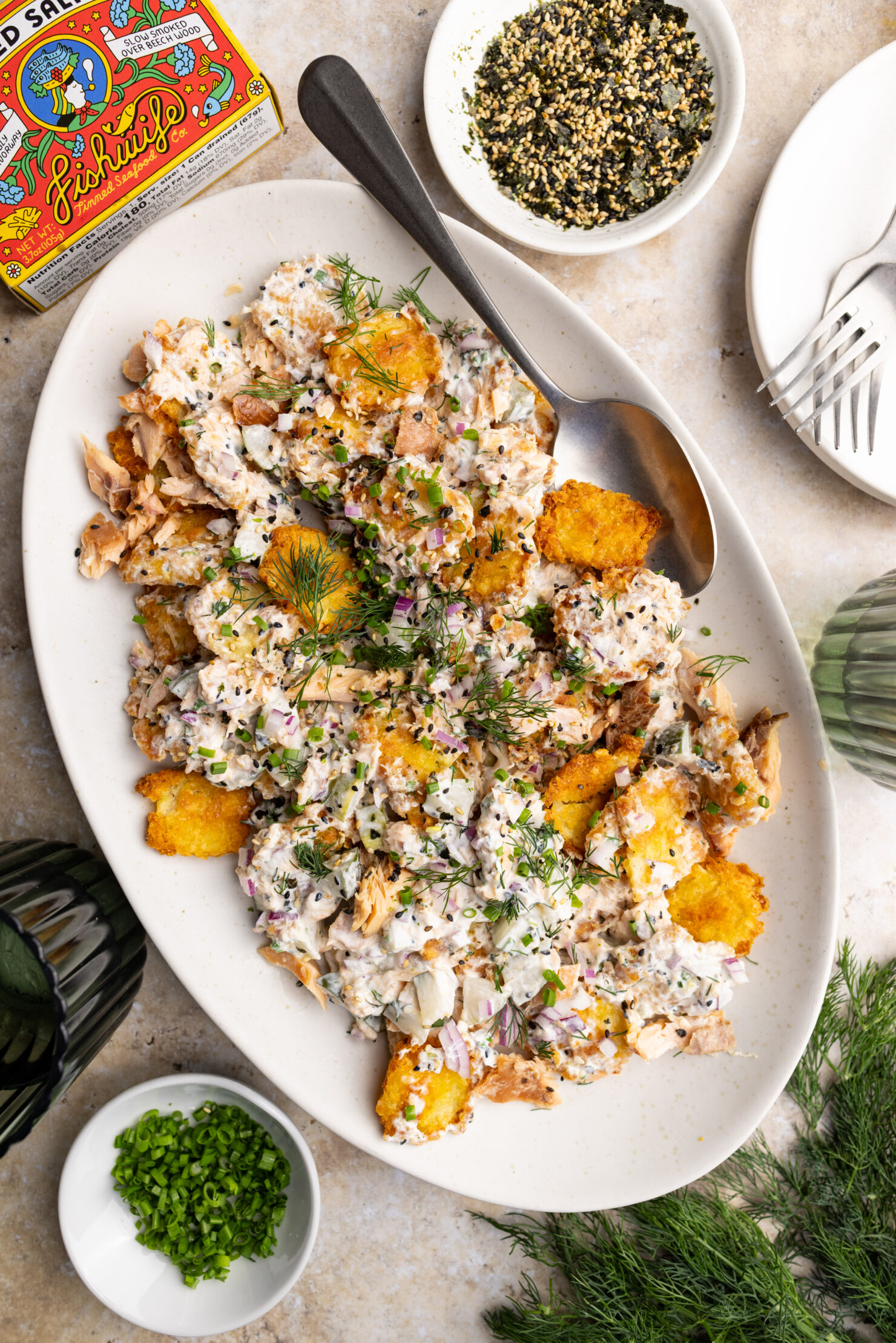 a serving plate of crispy potato salad garnished with more furikake and extra herbs