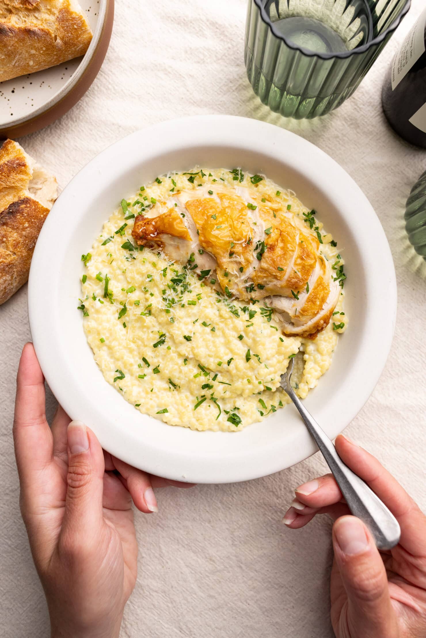 a bowl of garlic parmesan pastina topped with roasted chicken breast.