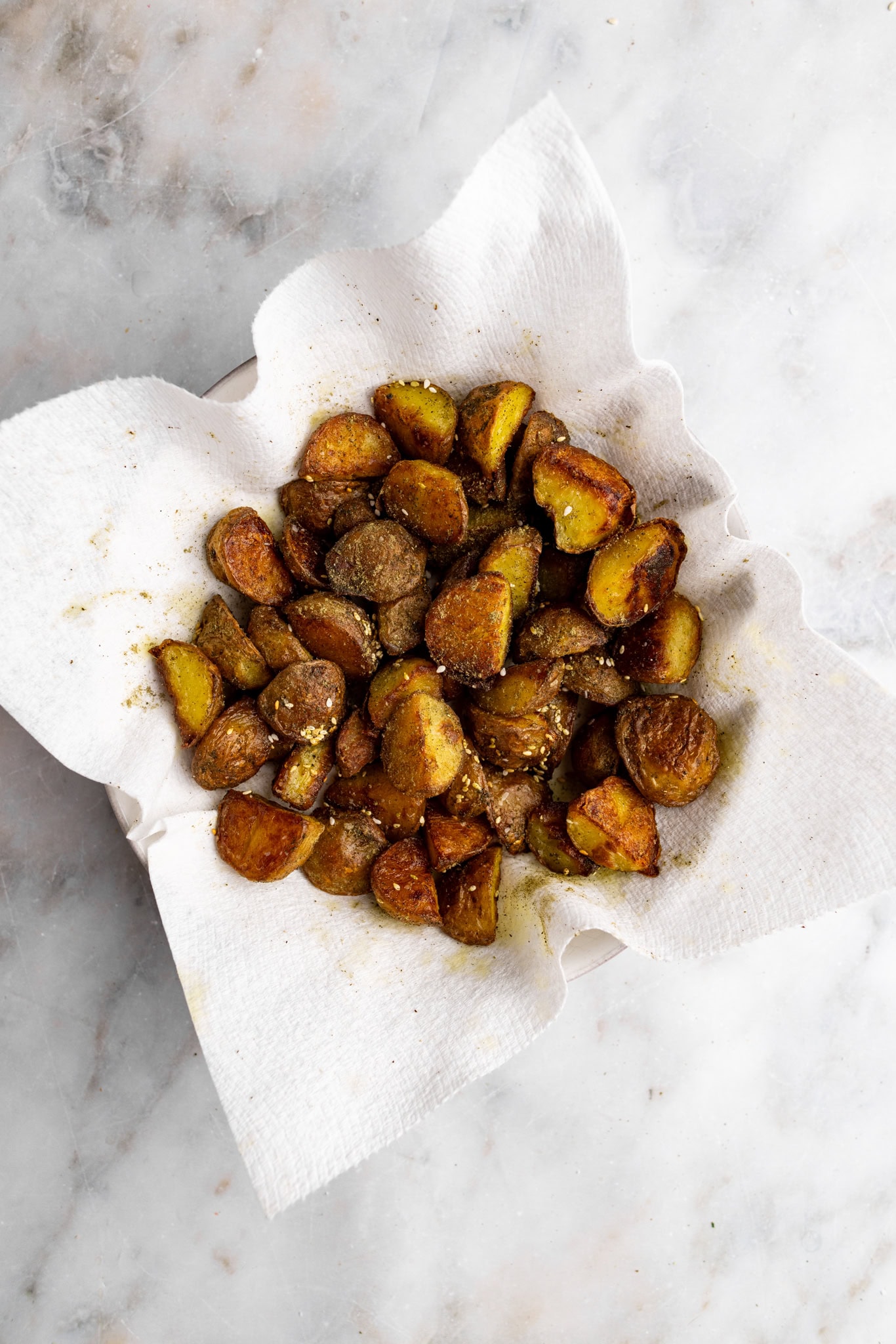 step by step: coating the potatoes in za'atar seasoning.