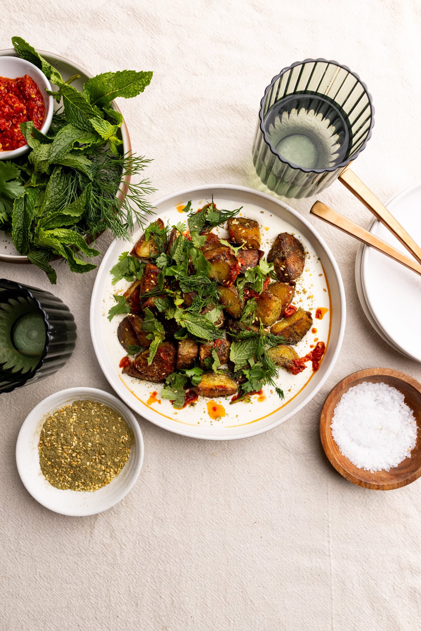 crispy za'atar potatoes over whipped feta topped with herbs and harissa.