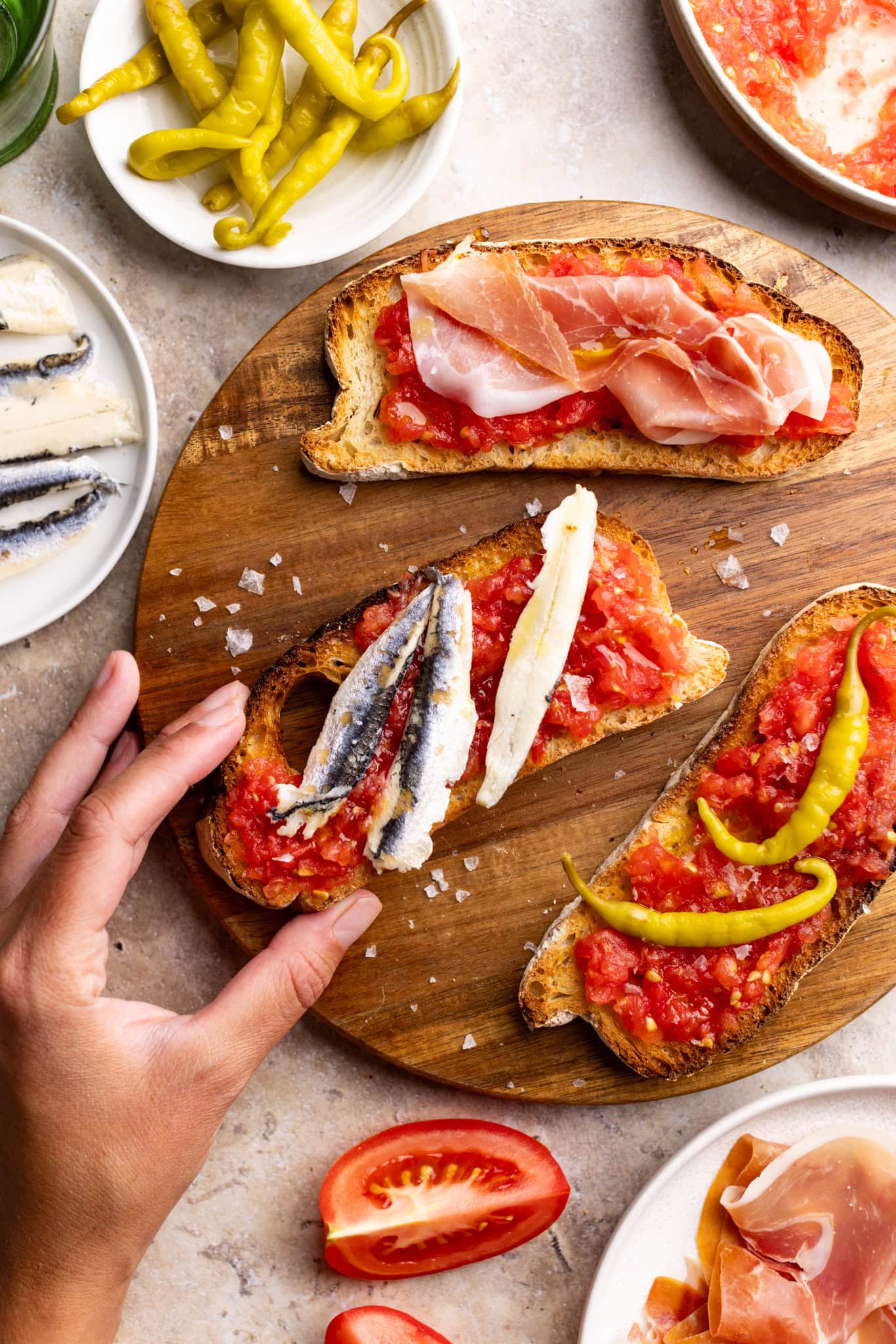 board of pan con tomate, topped with anchovies, prosciutto, and peppers