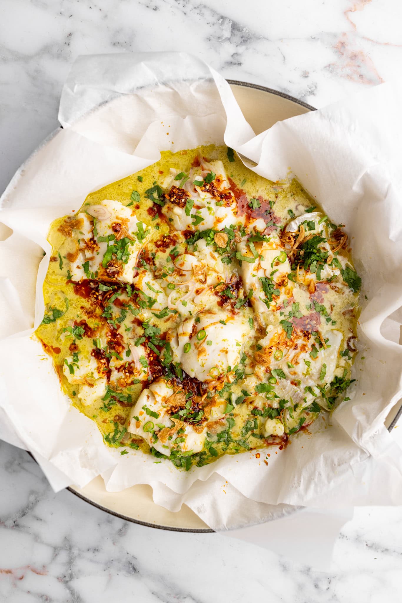 step by step: finished one pot Thai green curry fish topped with chili crisp, cilantro, and shallots.